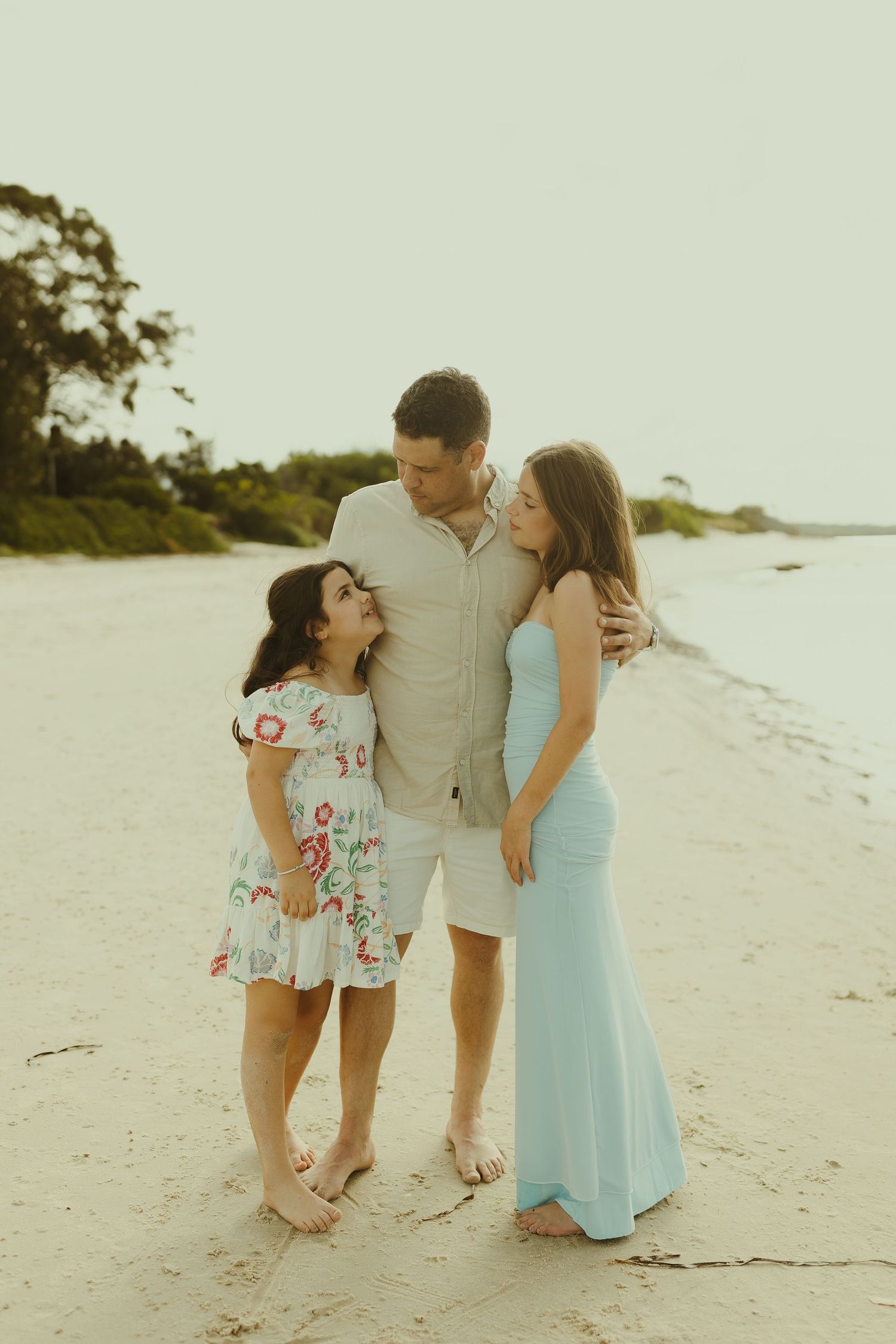 Family sharing a tender moment together on a sunny beach.