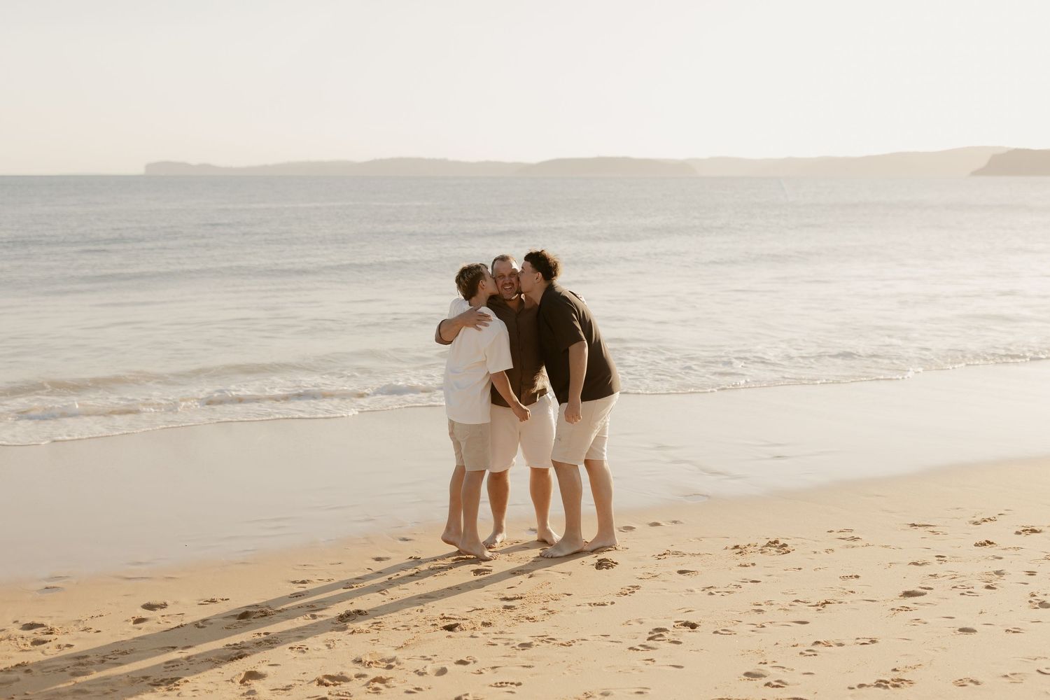 Friends enjoying a carefree moment walking along the shoreline at golden hour.