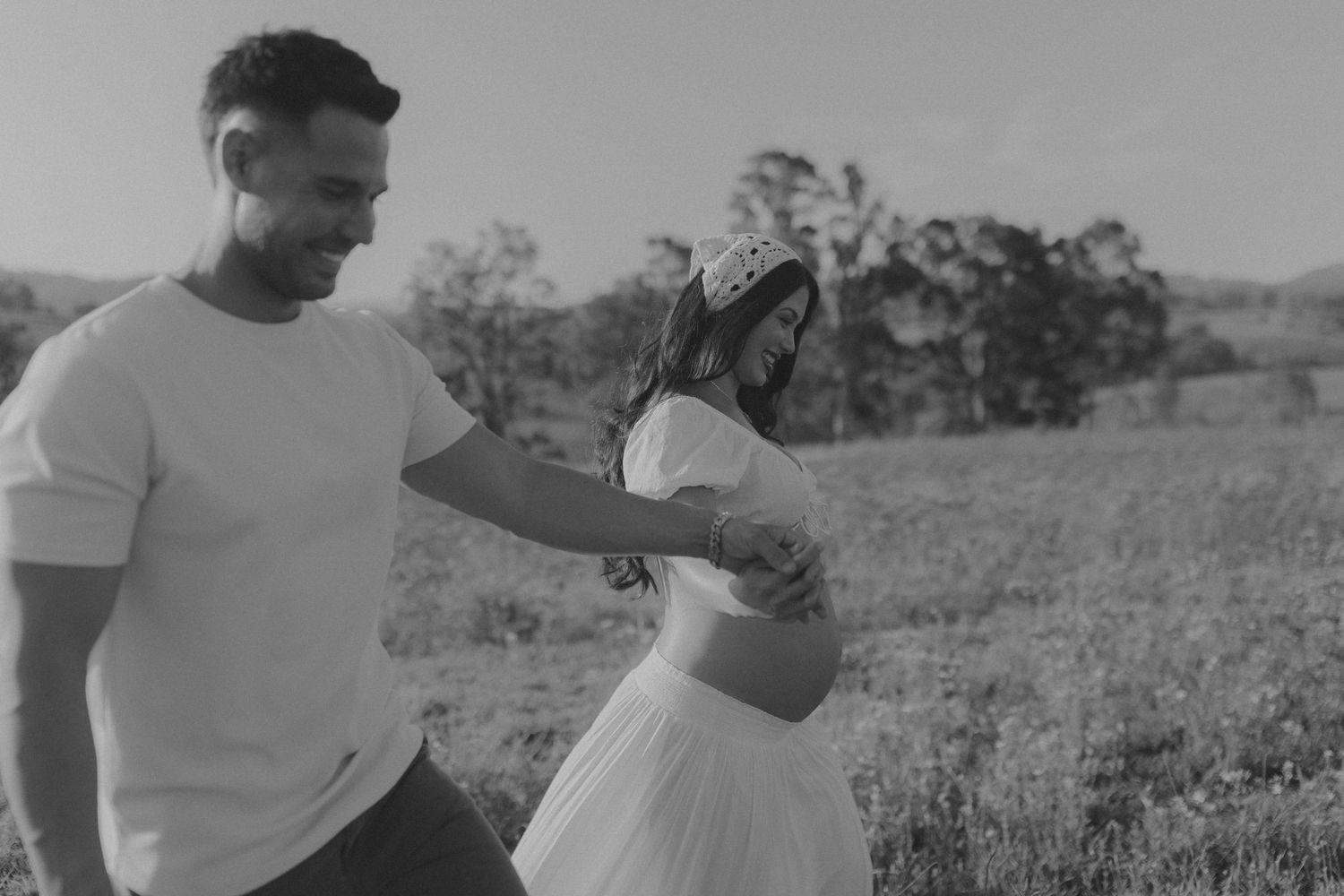 Black and white photograph capturing intimate moments in a wildflower field.