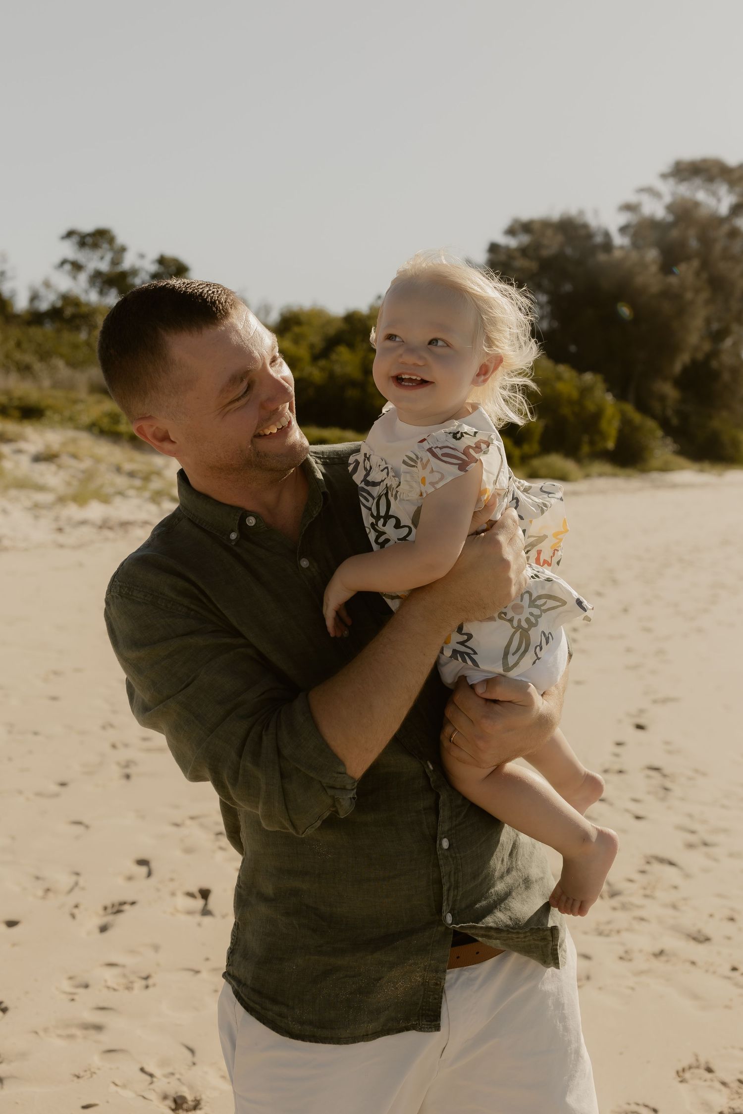 Sweet moments captured between parent and child playing together on a sunny beach.