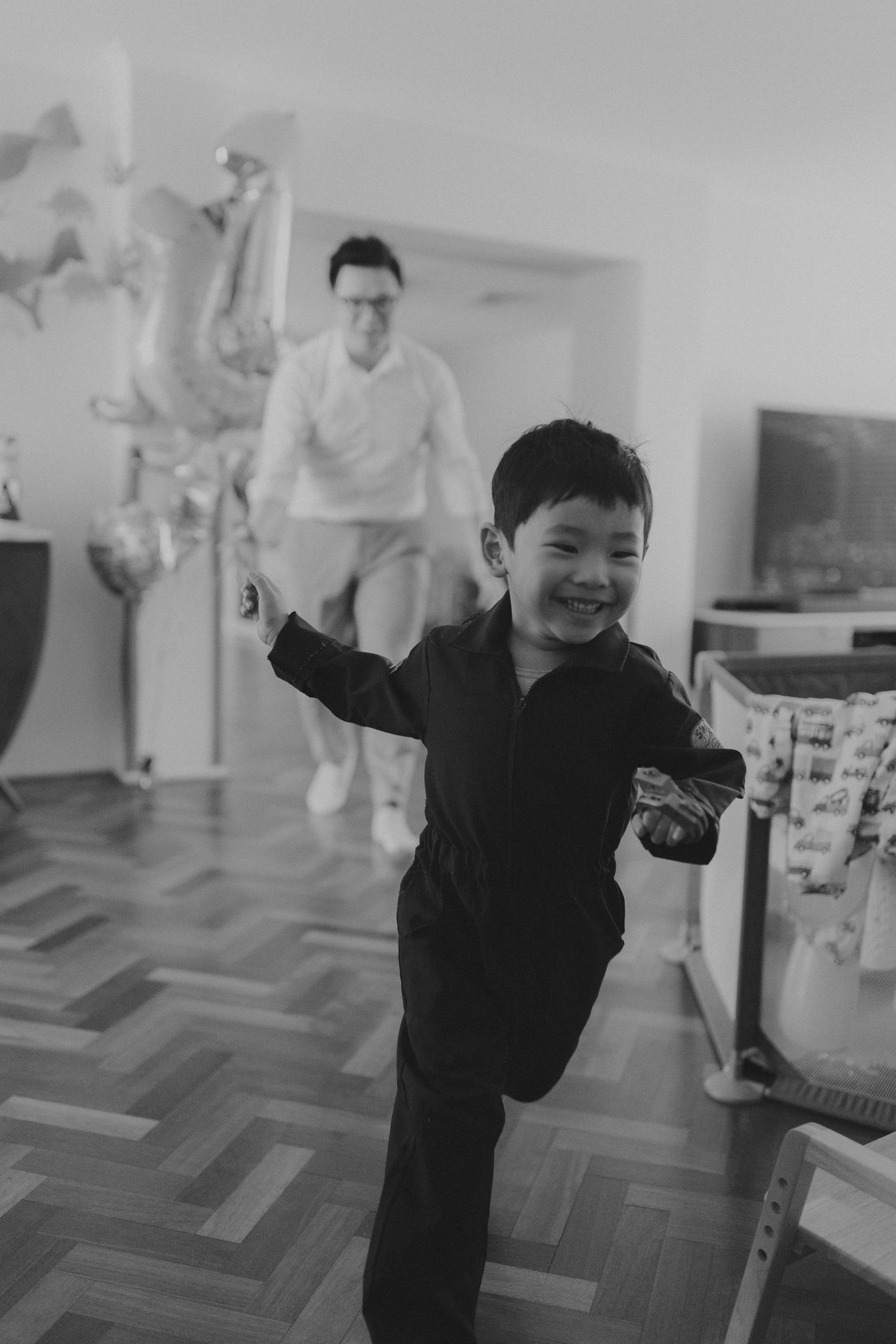 Black and white sequence of a child jumping and playing energetically on a patterned floor.