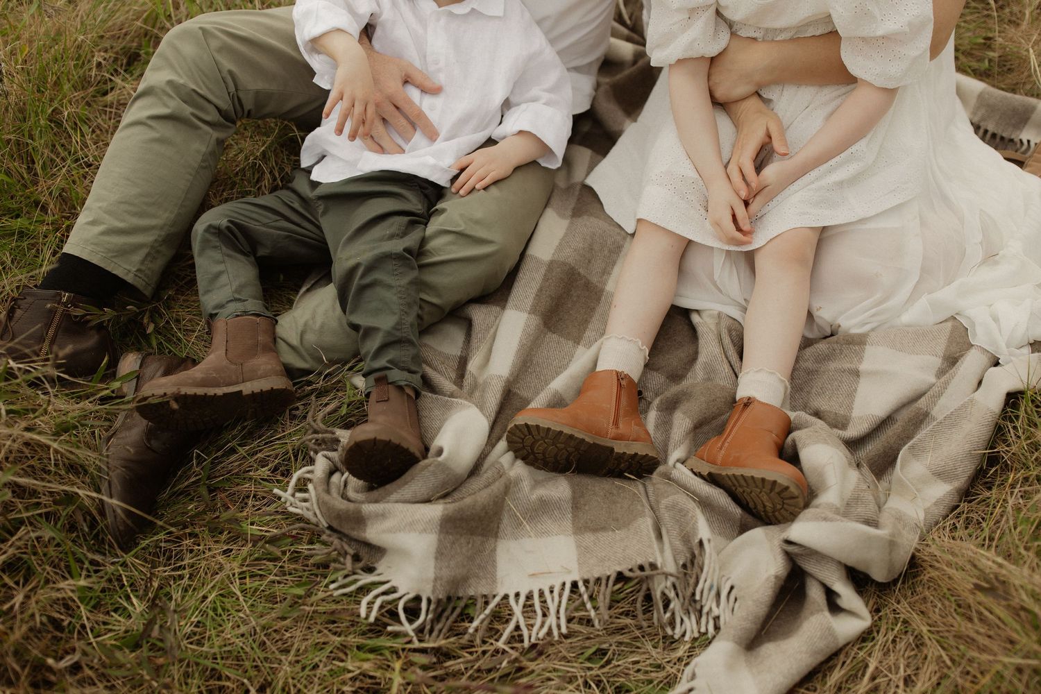 Close-up detail shots of rustic leather shoes and white fabric in outdoor field setting.