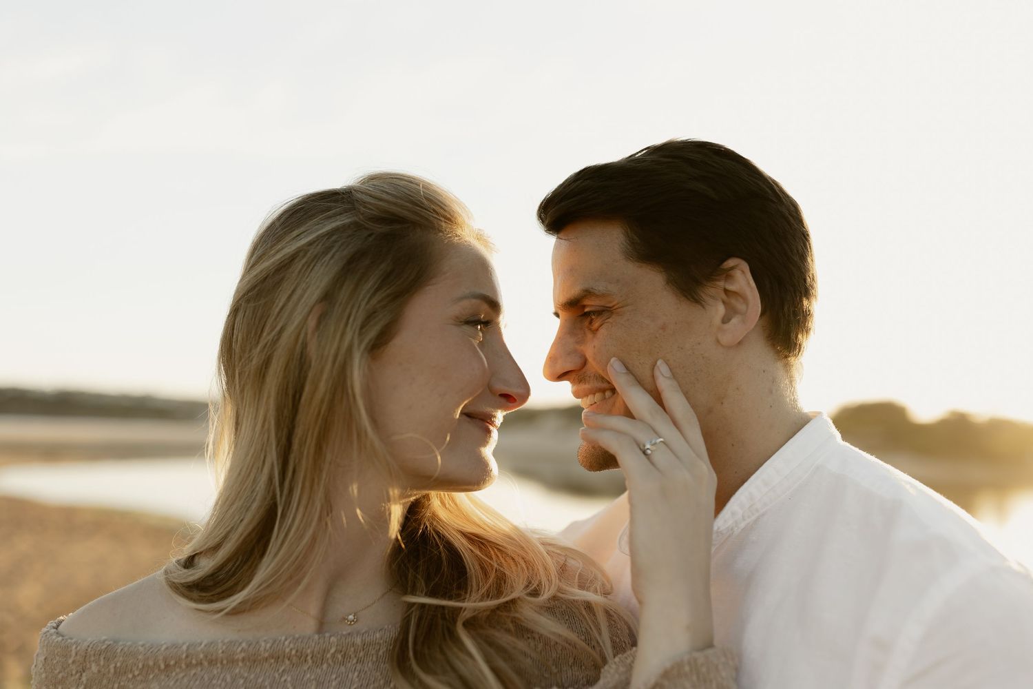 Romantic couple sharing tender moments during a sunset photoshoot outdoors.