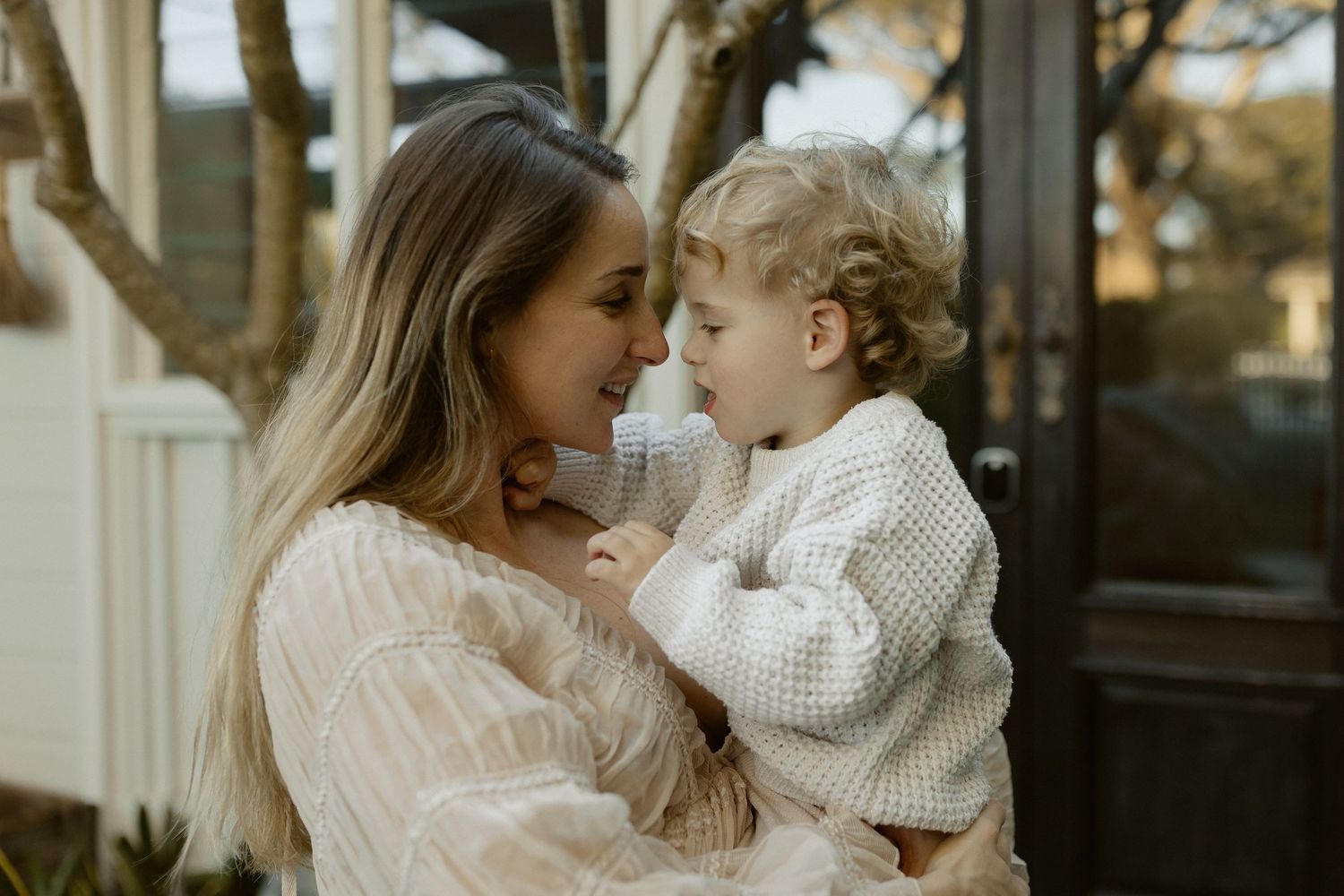 Outdoor portrait in soft natural light with cozy knit sweaters and gentle expressions.