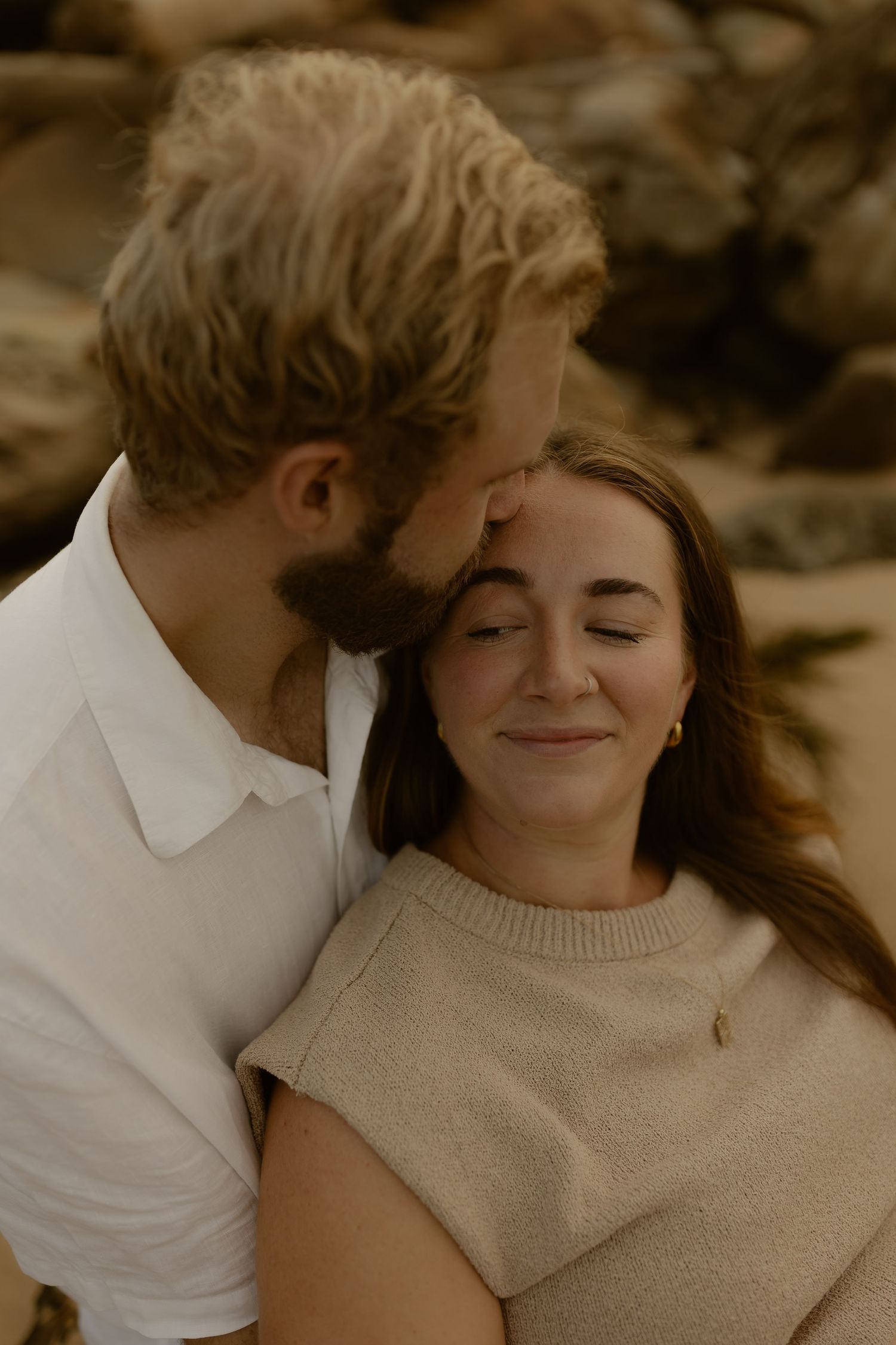 A romantic sepia-toned photo series showing tender moments between a couple in casual attire.