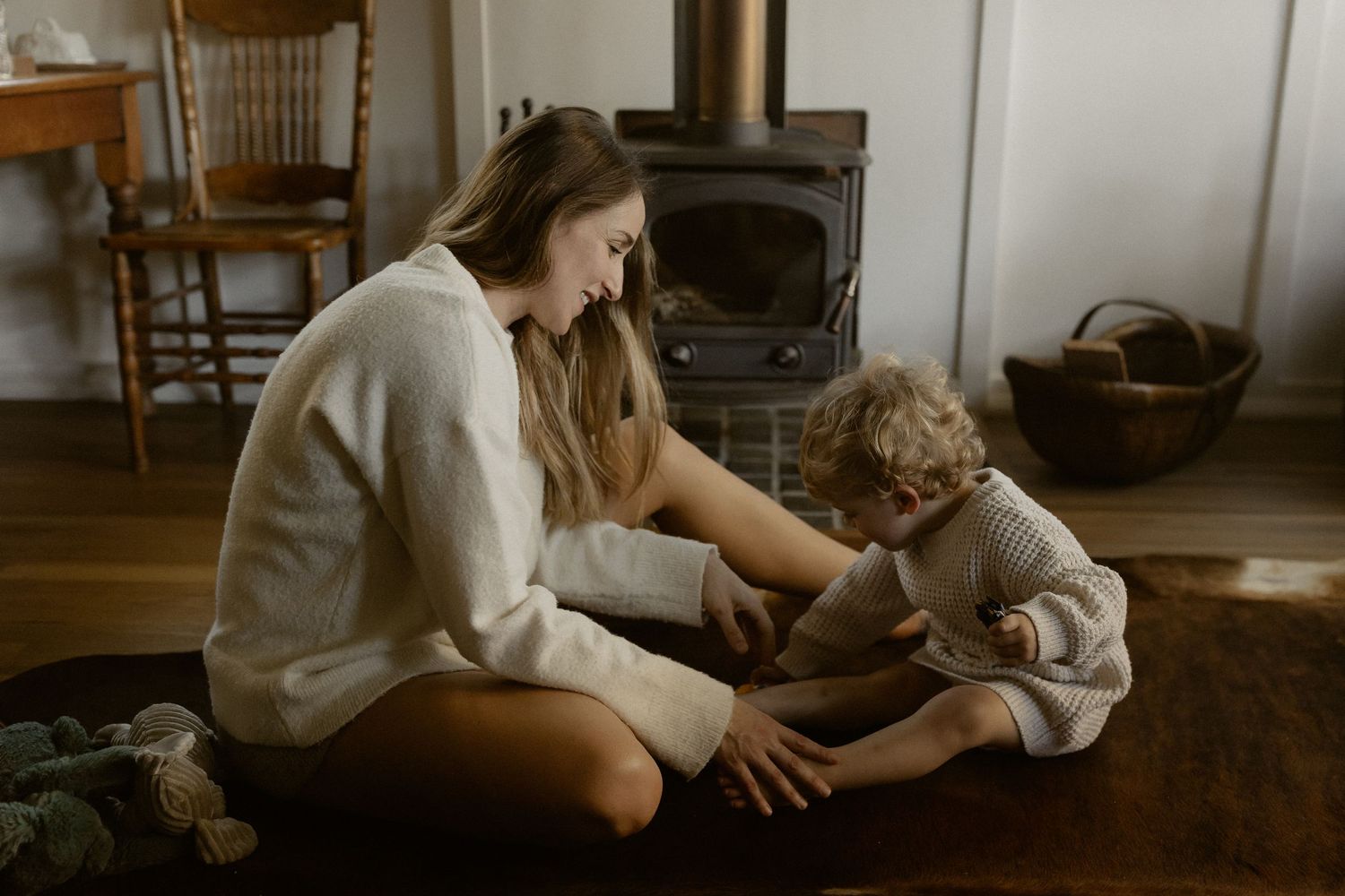 Cozy scene by a wood stove showing intimate interaction on hardwood floors.