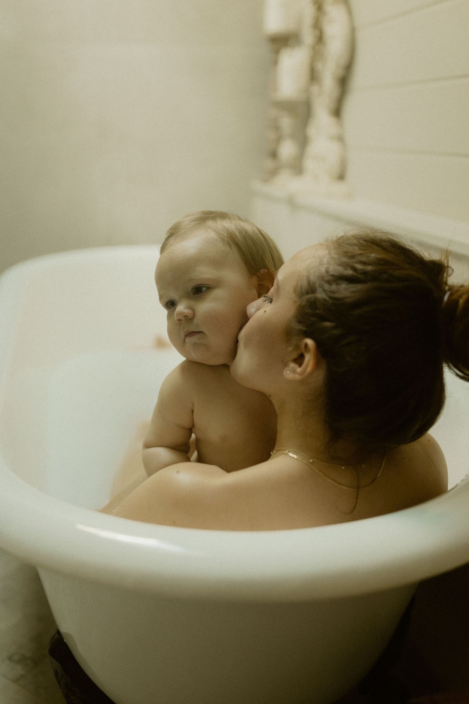 A peaceful bathtime moment captured in a vintage clawfoot tub with soft natural lighting.