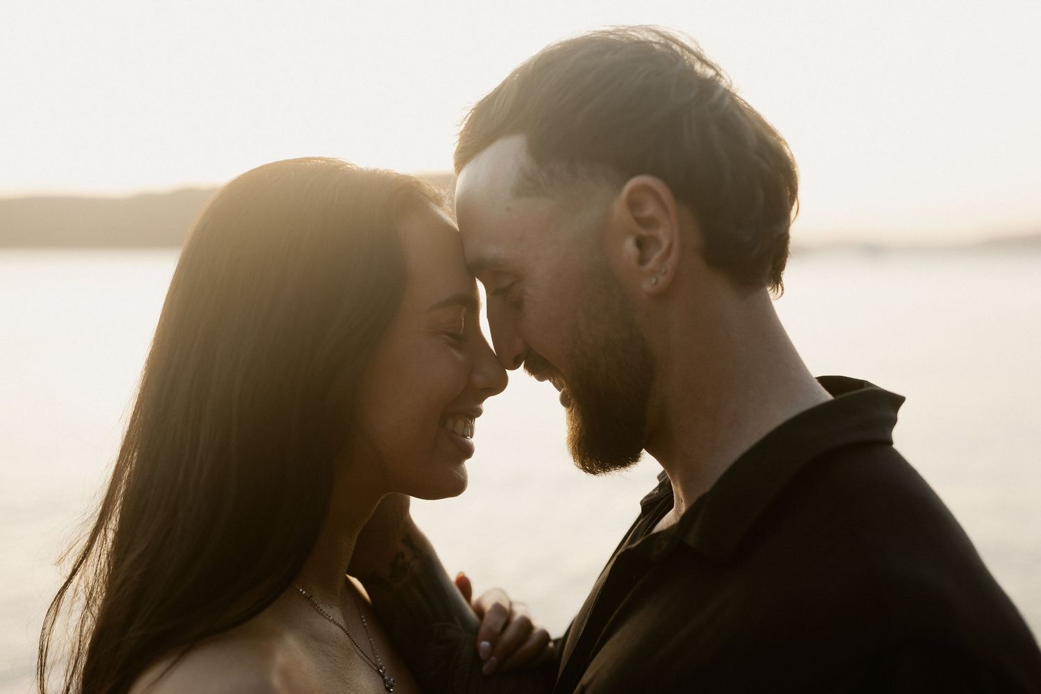 Close-up silhouette of a couple in an intimate embrace during golden hour.