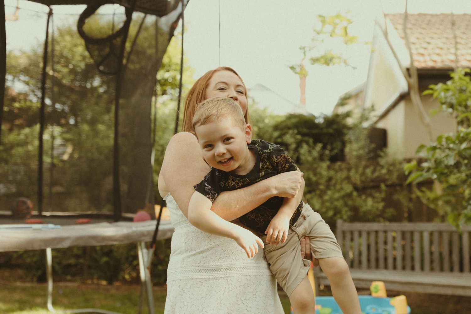 A series of candid outdoor photos showing playful moments between a parent and child in a backyard setting.
