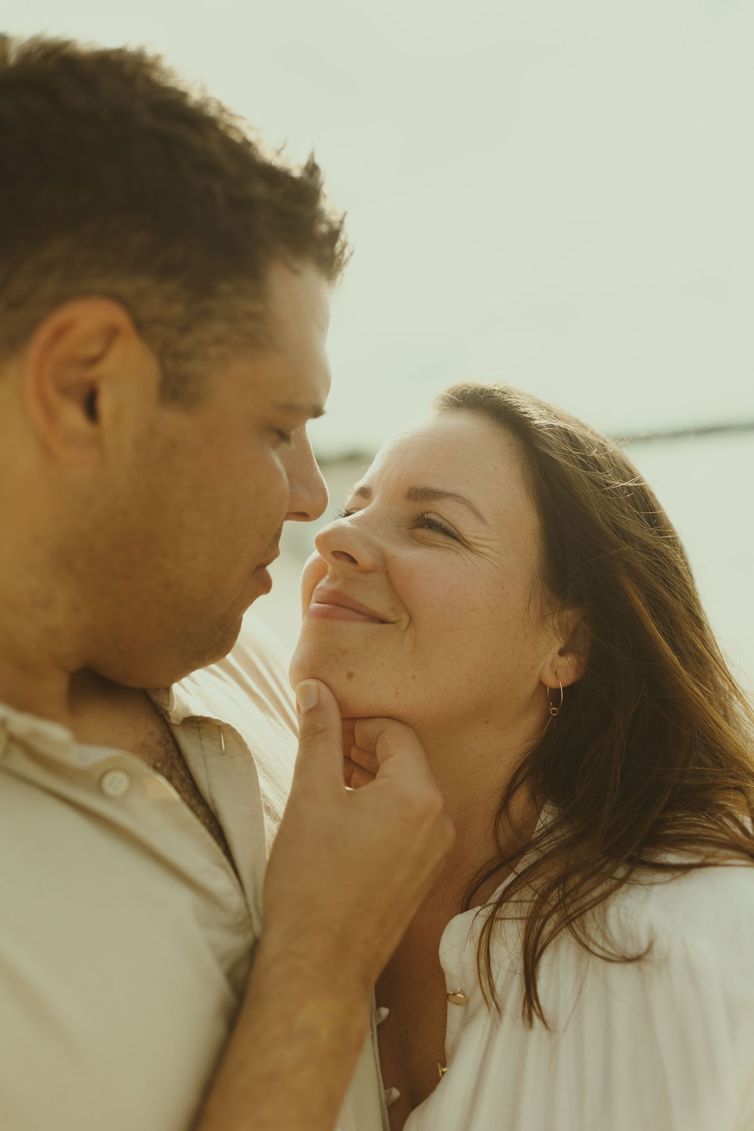 A romantic couple shares tender moments in a series of intimate photos with warm lighting and soft expressions.