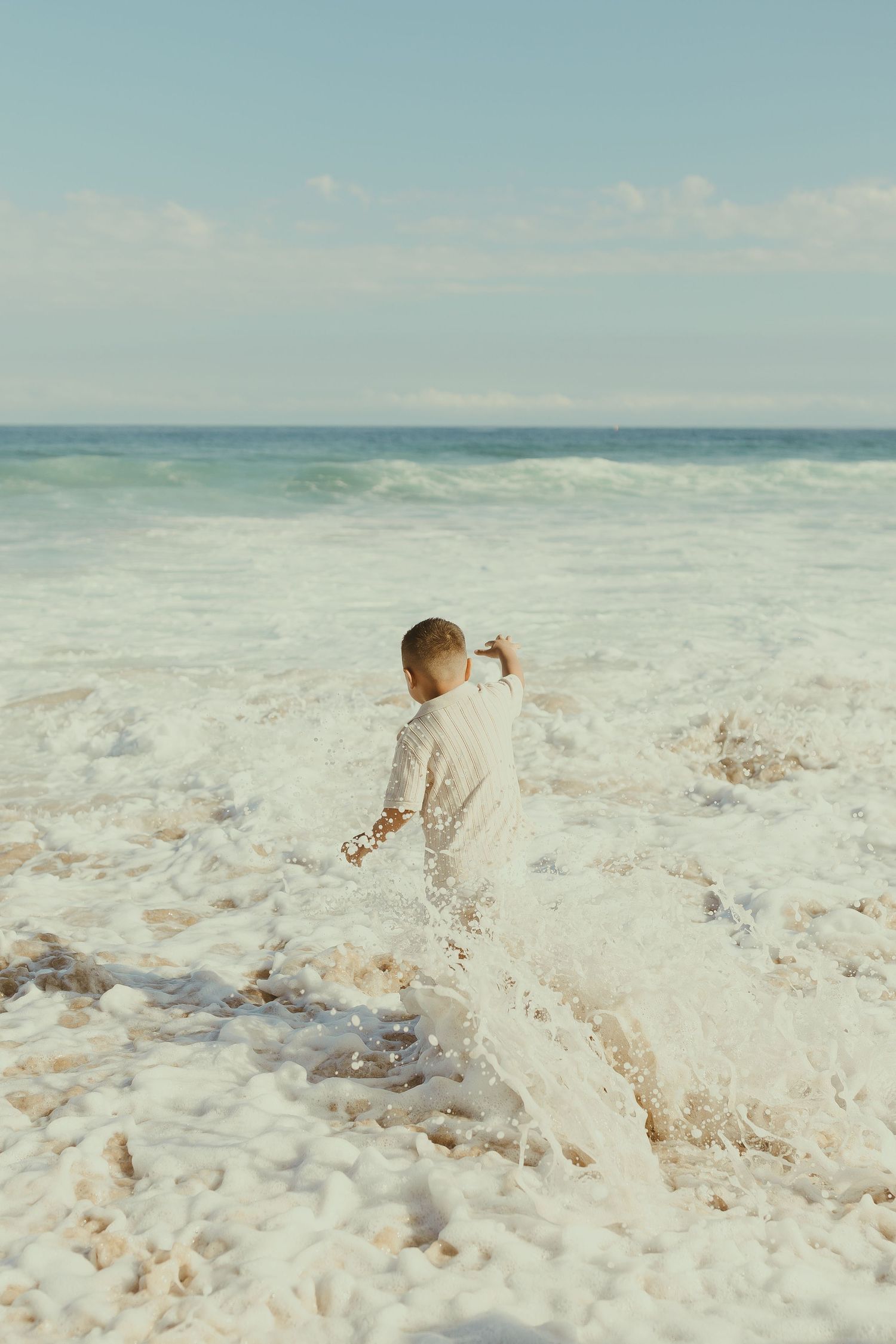 Sequence of photos showing waves crashing and splashing on a sunny beach with turquoise ocean waters in the background.