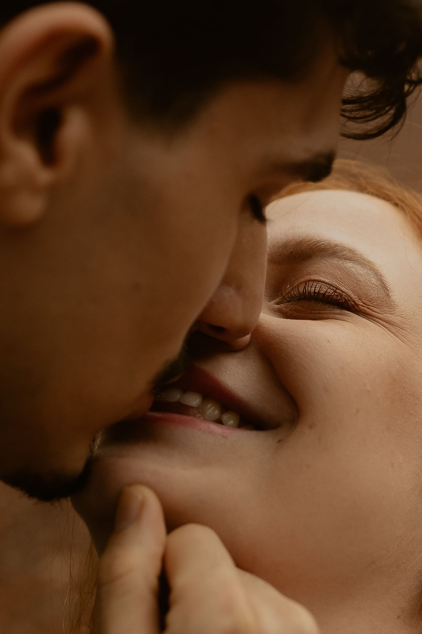 An intimate close-up portrait showing a tender romantic moment between two people.