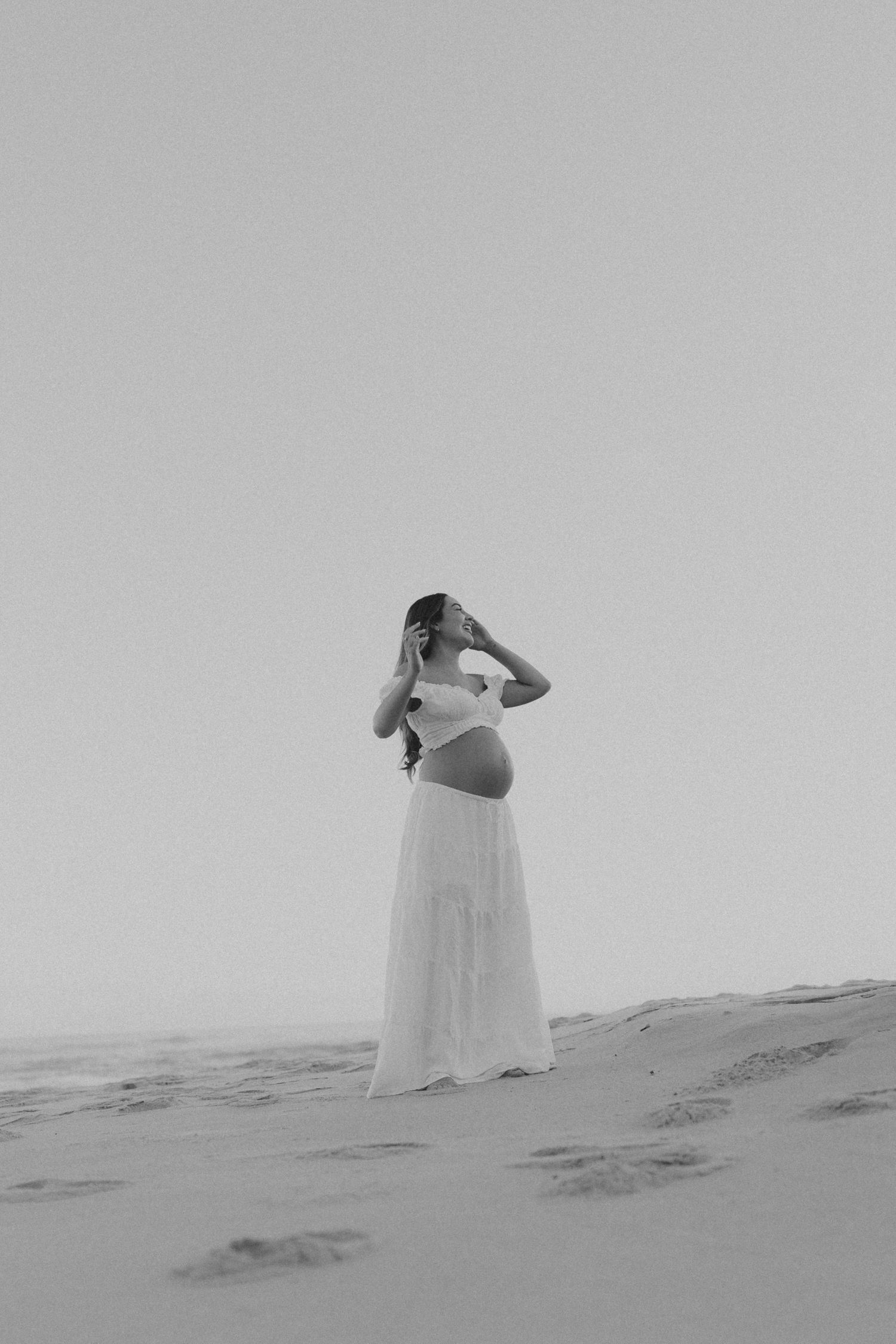 A sequence of black and white photos showing a ghostly figure in white fabric moving across a sandy landscape.