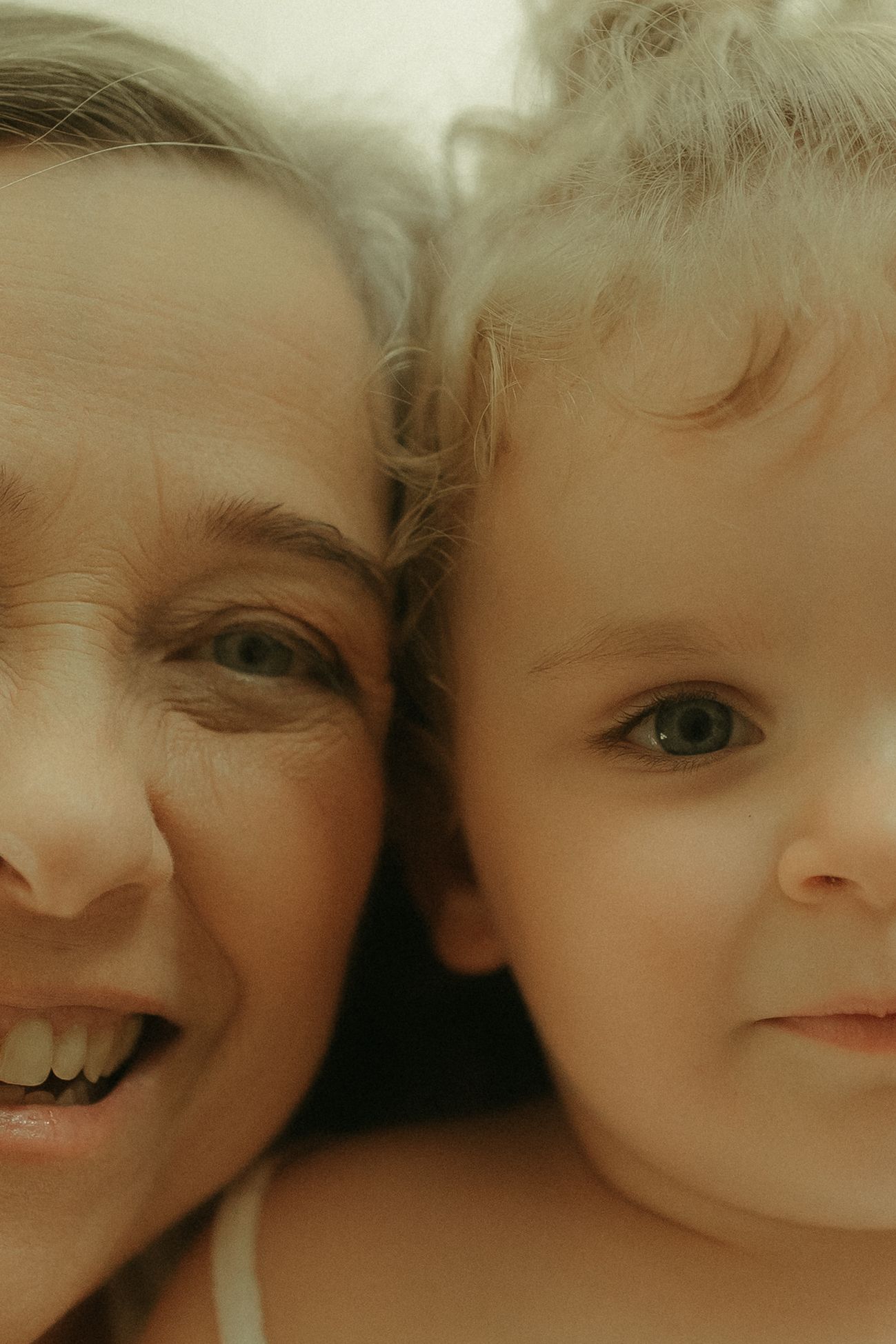 Two people share an intimate close-up moment against a soft, warm background.