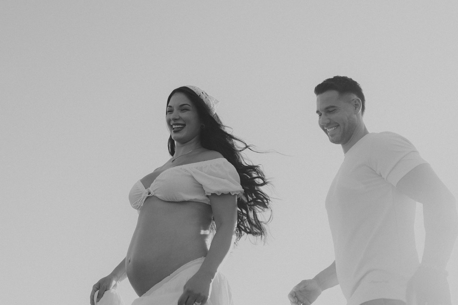 Black and white photo sequence showing a couple dancing together on a beach at sunset.