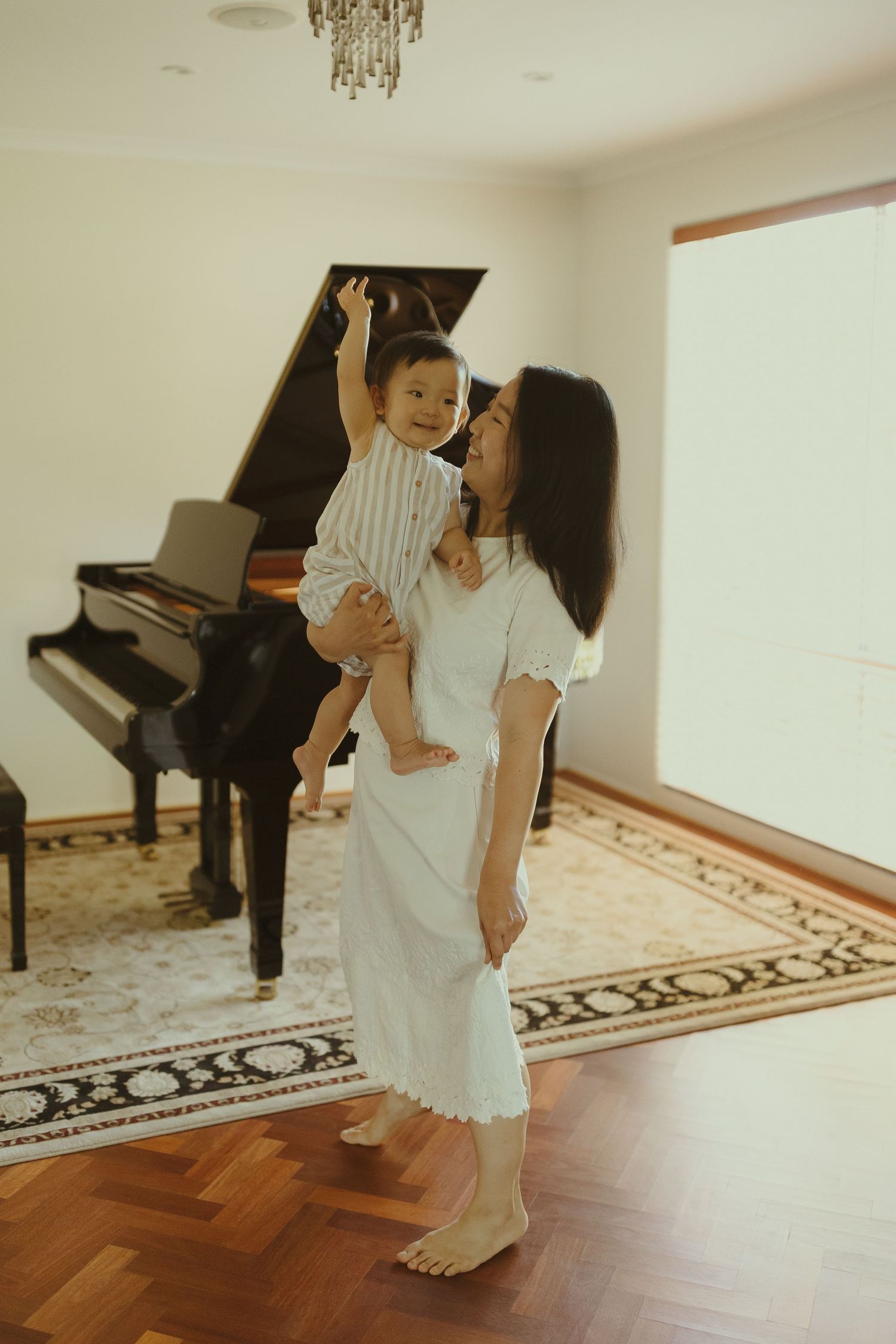 Sequence of tender family interactions in a room with a piano and decorative rug.