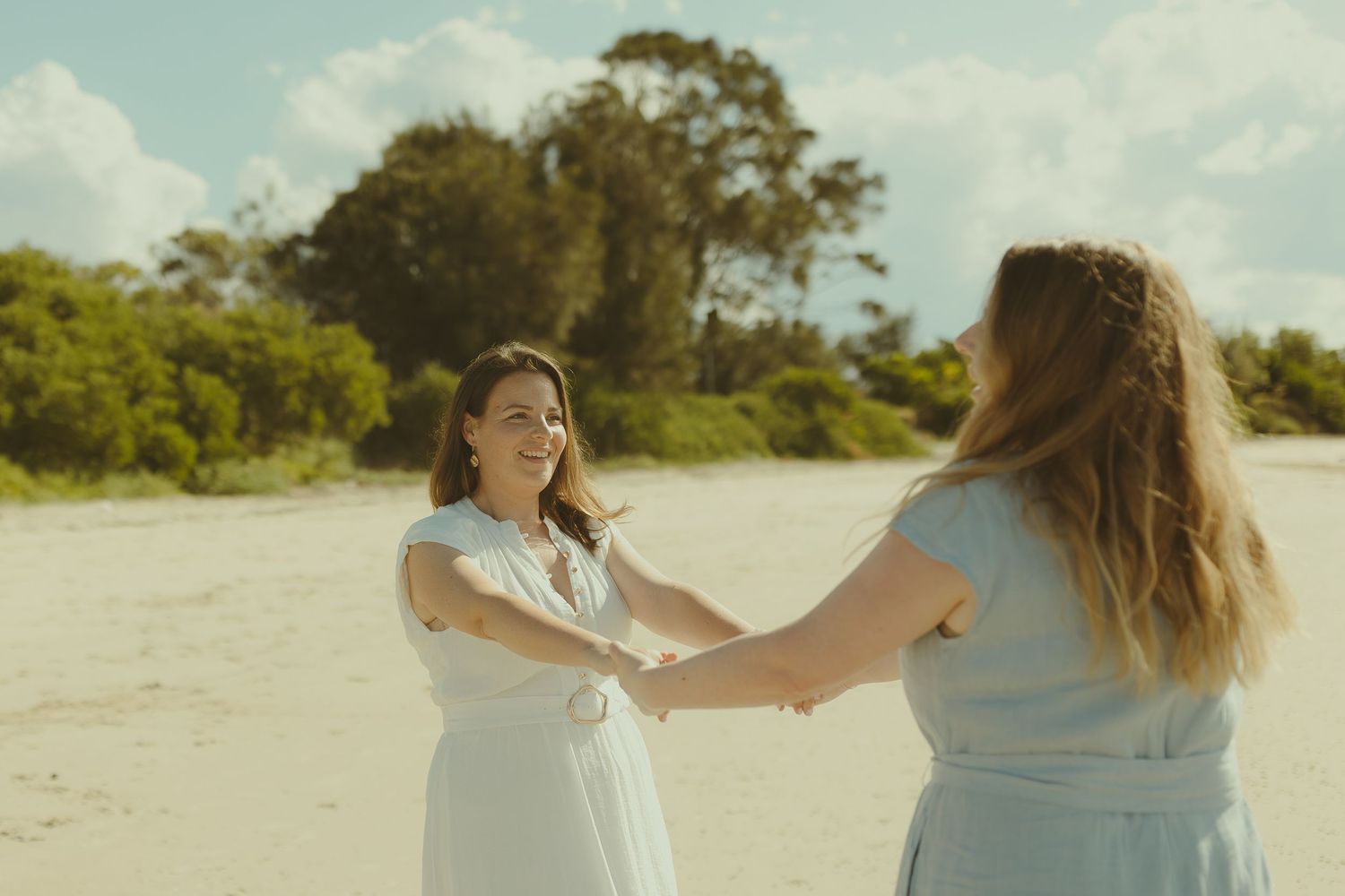 Two people sharing an emotional moment on a sunny beach.