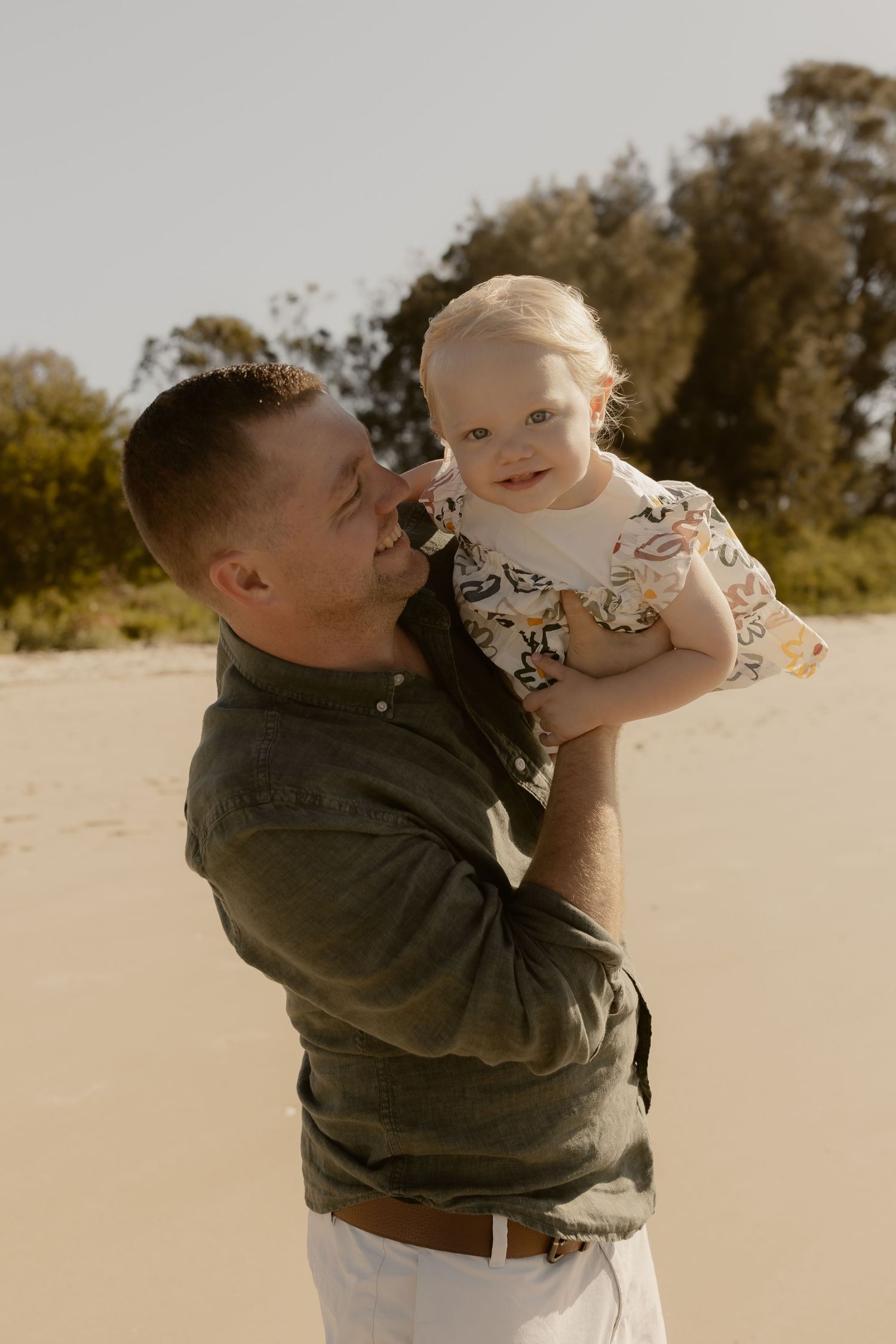 Parent and child sharing joyful moments together on a sunny beach, creating heartwarming memories.
