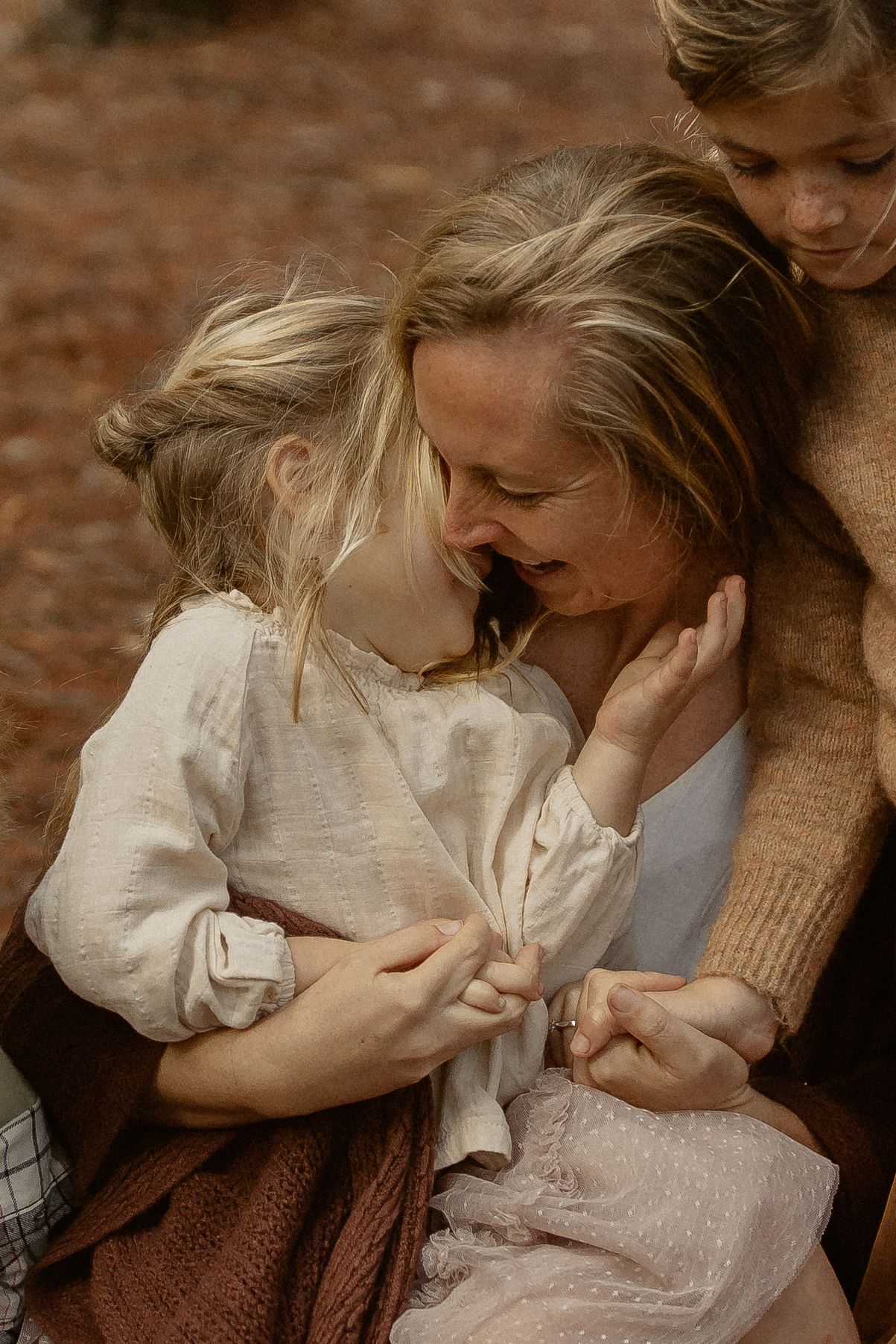 Intimate romantic couple embraces in vintage-style sepia portrait wearing earth-toned sweater and white blouse.
