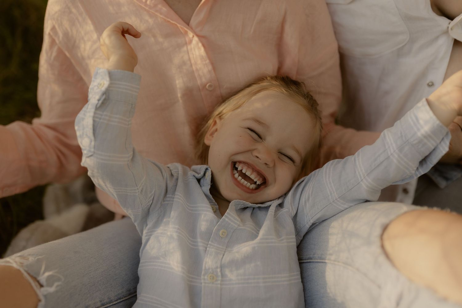 Candid family laughter and joy captured in warm natural lighting.