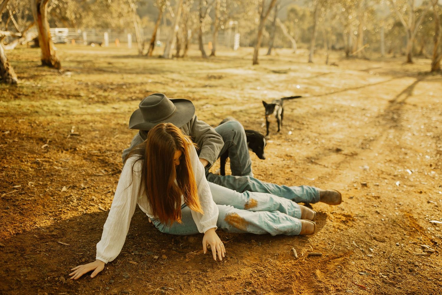 People relaxing on dusty outback trail with kangaroo in background on sunny Australian afternoon.