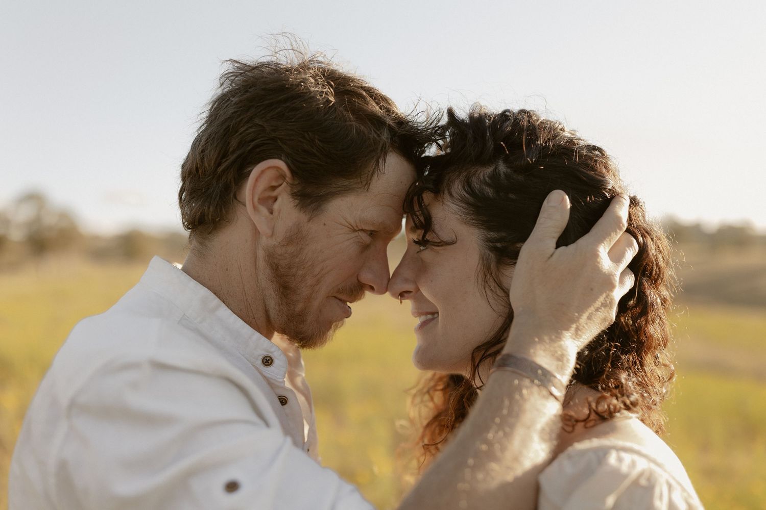 A romantic moment captured in soft lighting against a bright white background.