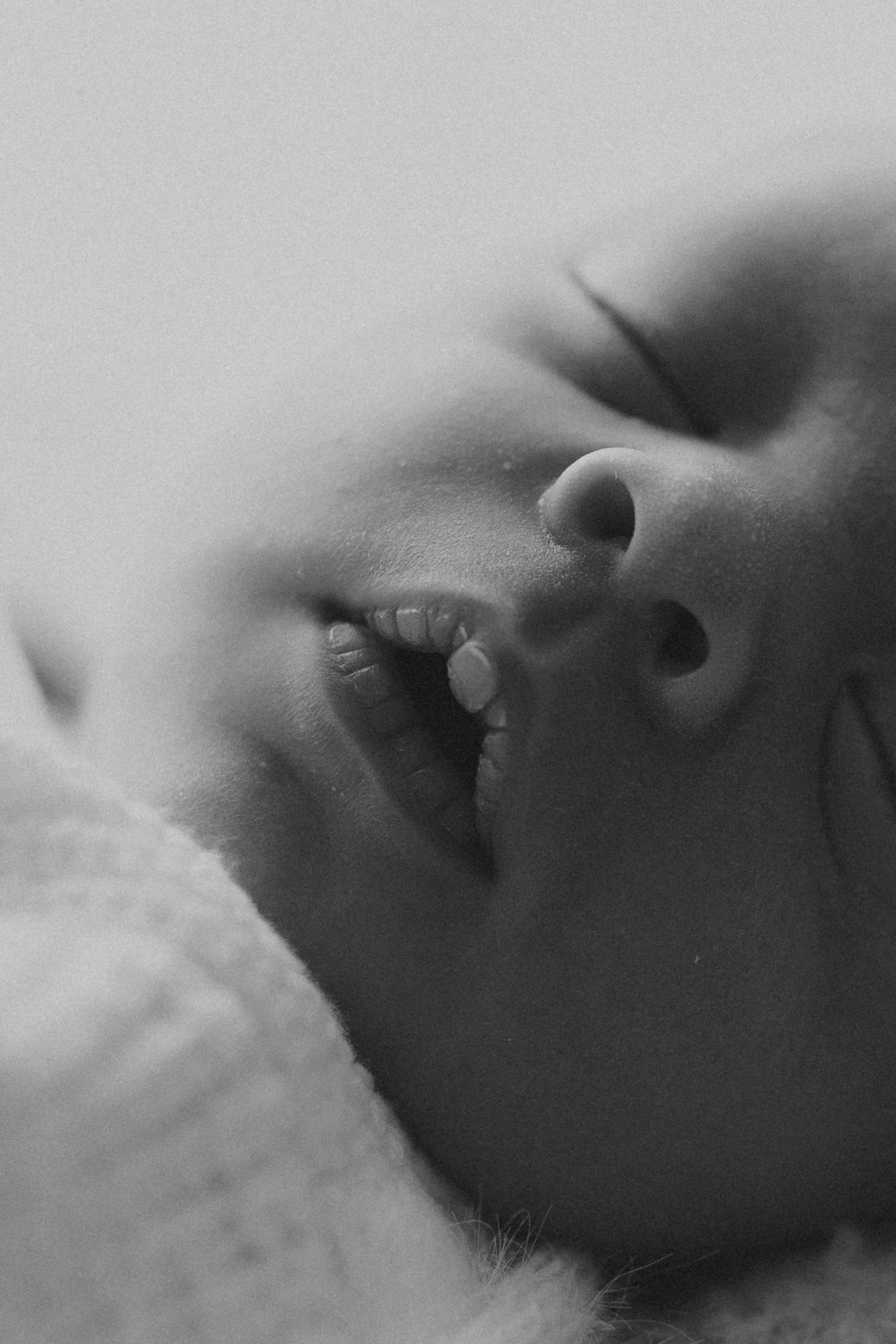 Artistic black and white macro photography series showing close-up details of lips and facial features in soft focus.