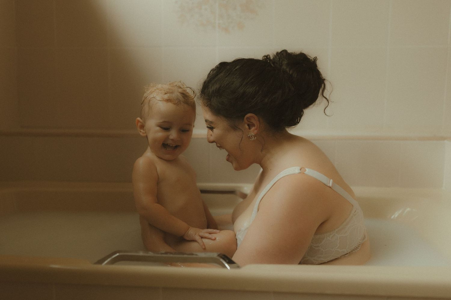 A series of sepia-toned photos showing tender moments between parent and child during bathtime.