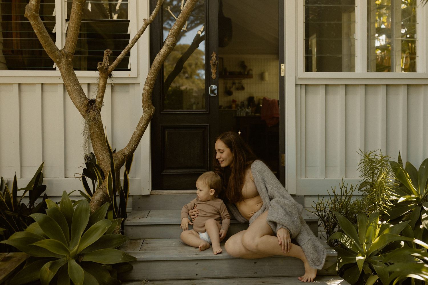 Relaxed outdoor porch scene with plants and white architectural details.