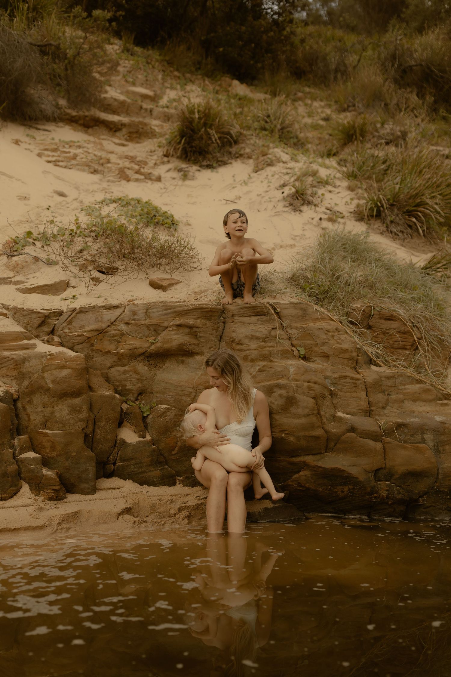 A sequence of images shows someone sitting and relaxing by a rocky pool of dark water in a natural outdoor setting.