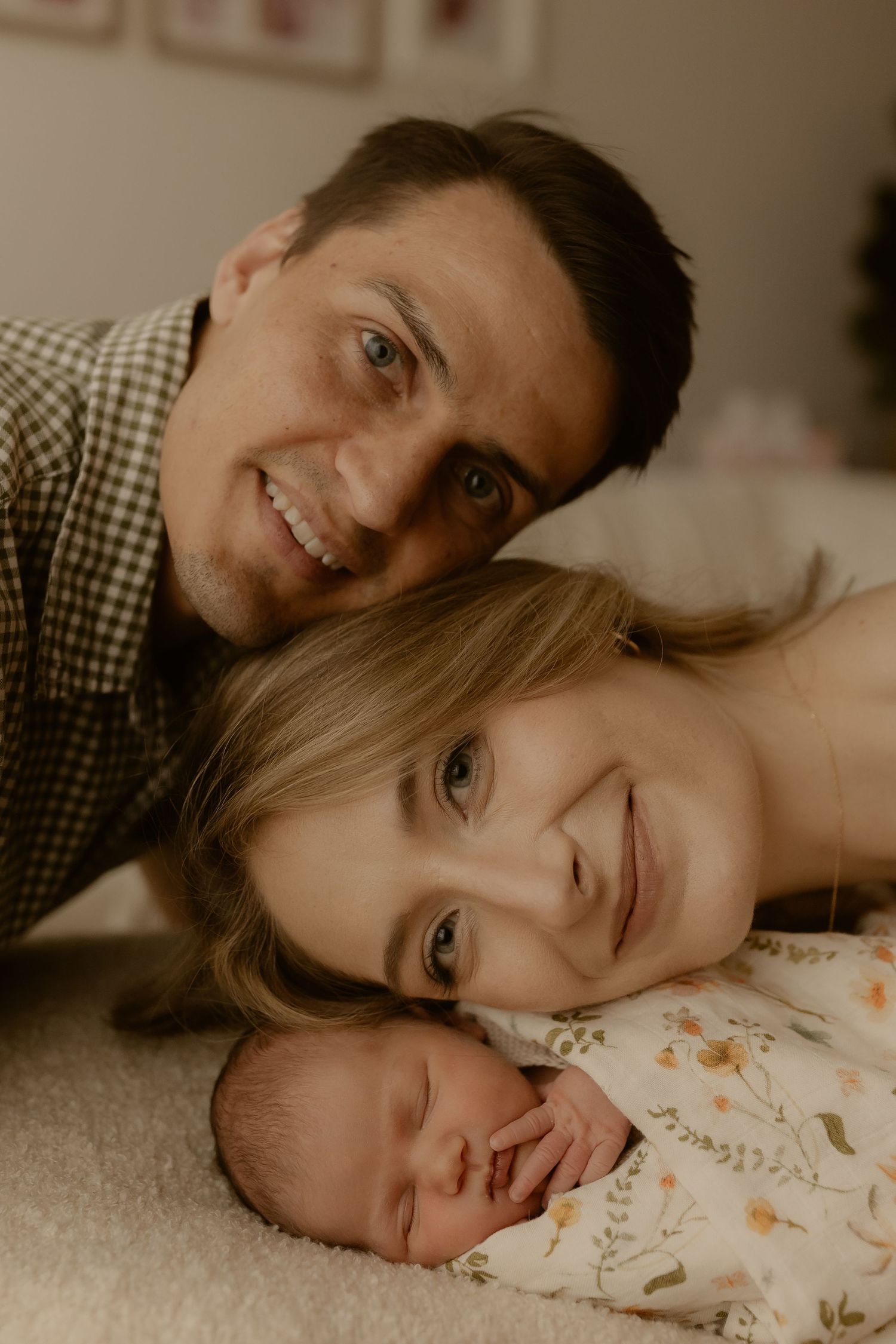 Candid family portrait showing tender moments with newborn in warm lighting.