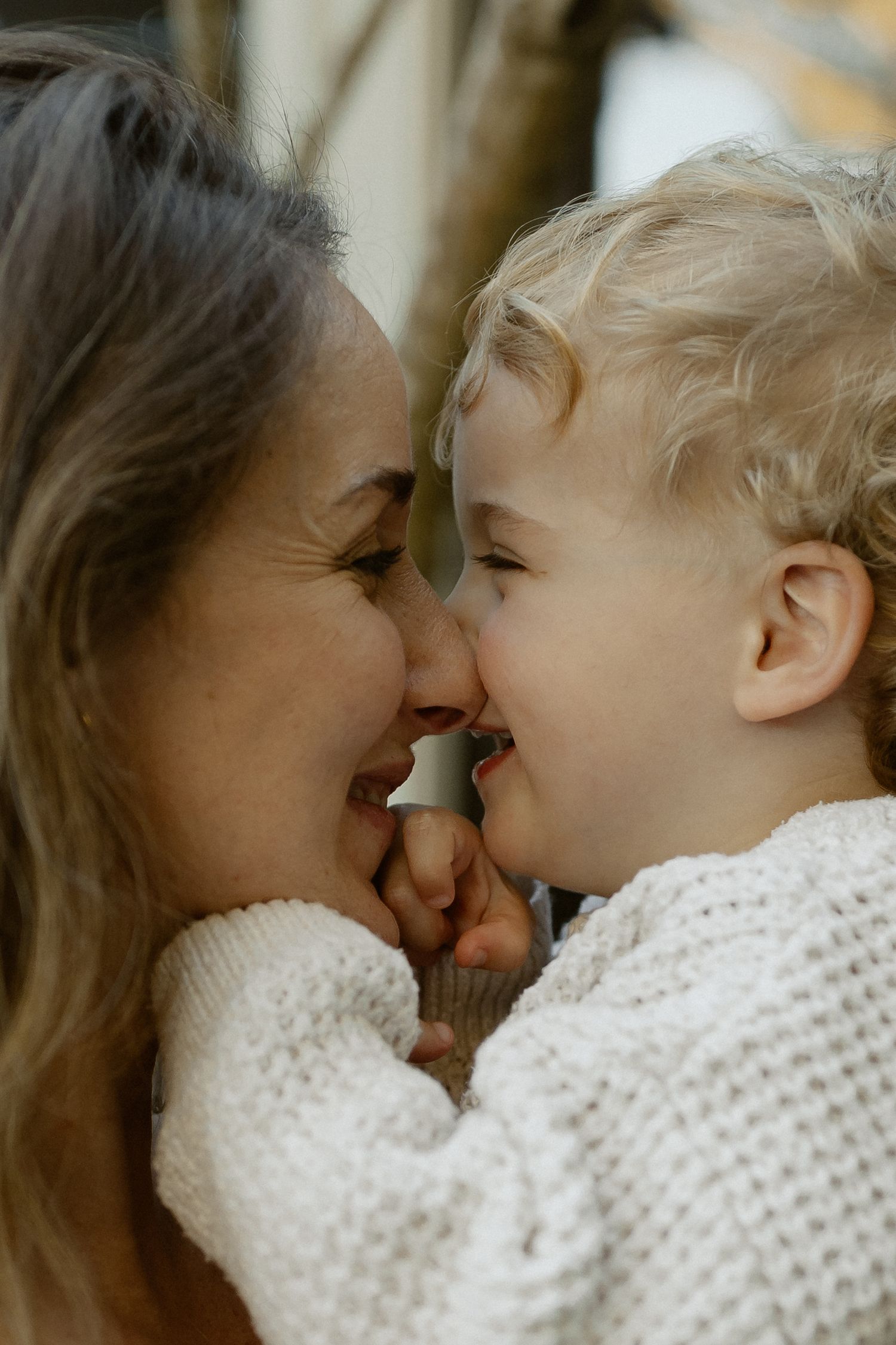 Close-up portrait capturing intimate nose-to-nose moment in natural light.