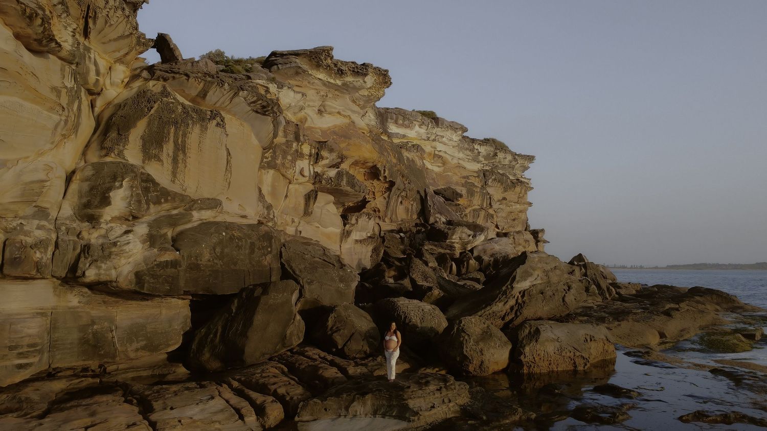 Panoramic view of rugged coastal cliffs and rock formations along a scenic oceanfront shoreline.
