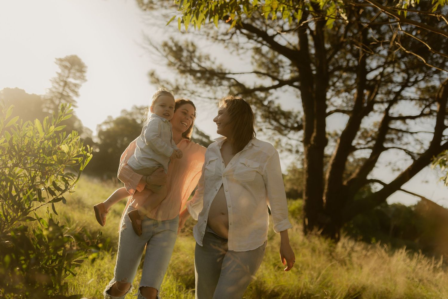 Natural family portraits captured in warm sunlight with joyful expressions and movement.