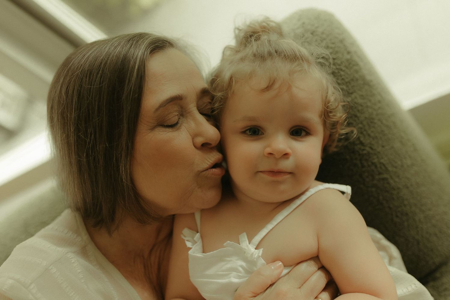 Close-up portrait of tender family affection in soft indoor lighting.