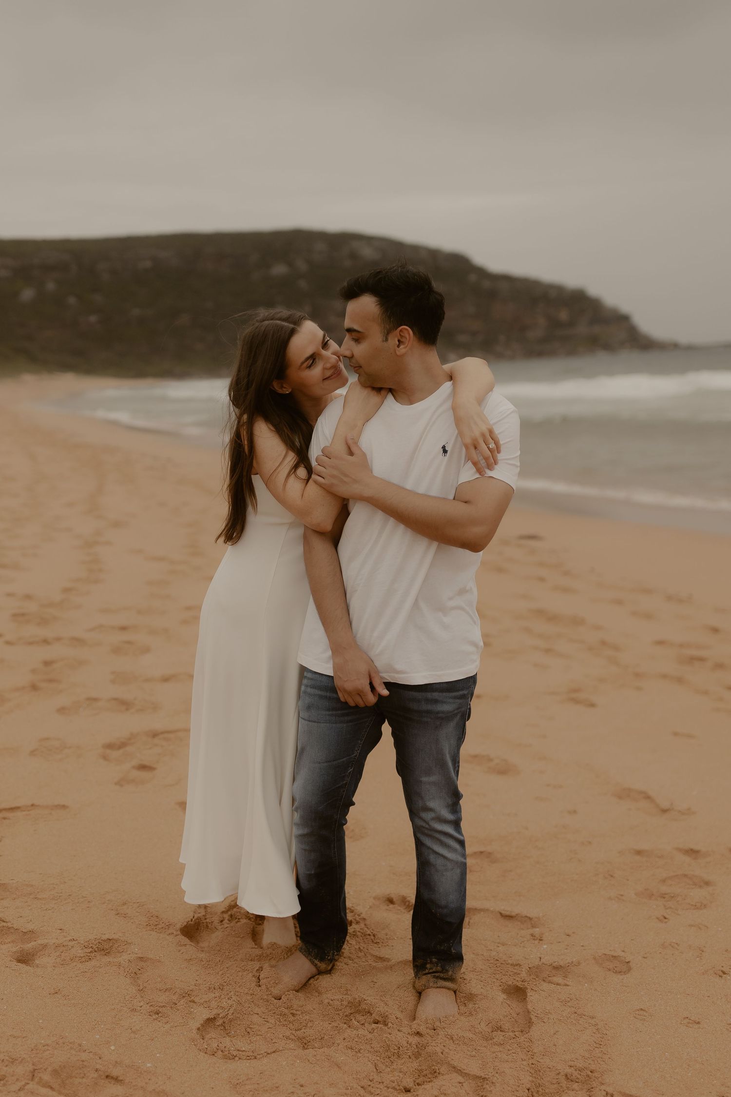 A romantic moment shared between two people dancing on a sandy beach.