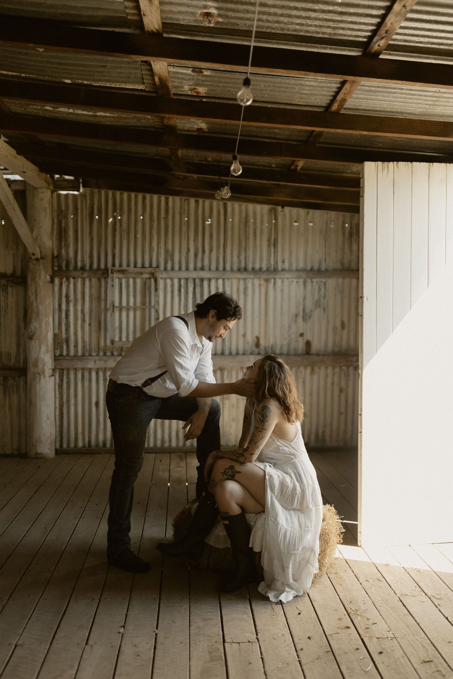 Dancing figures in a rustic barn interior with wooden floors and corrugated metal walls.