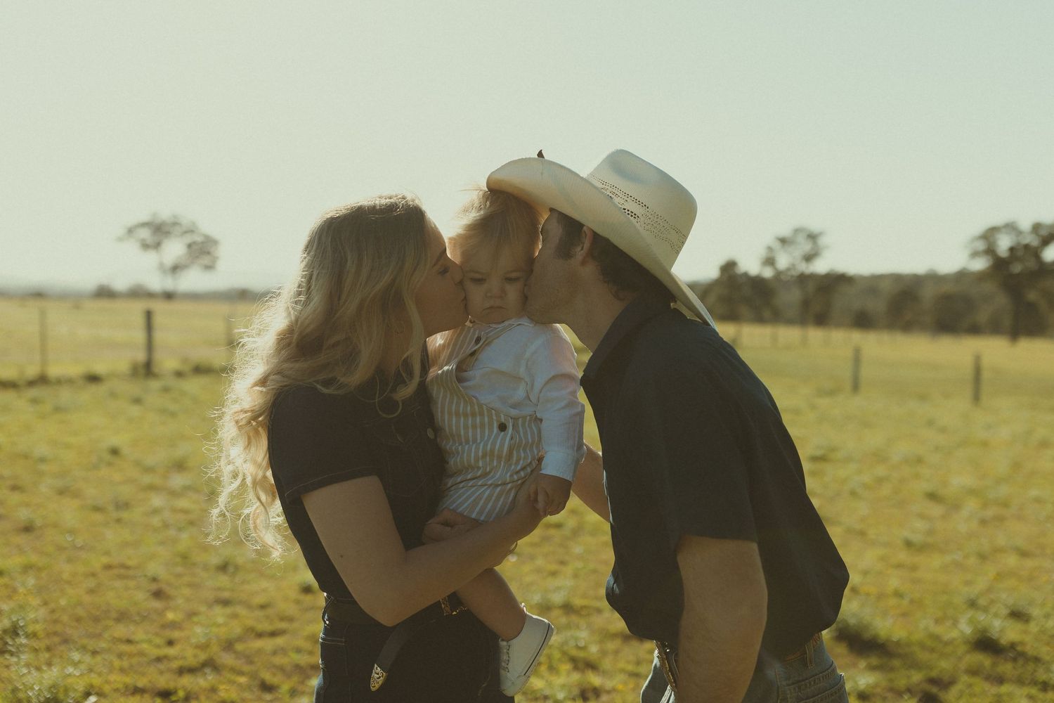 Intimate family photos showing affectionate moments in a sunlit field at golden hour.