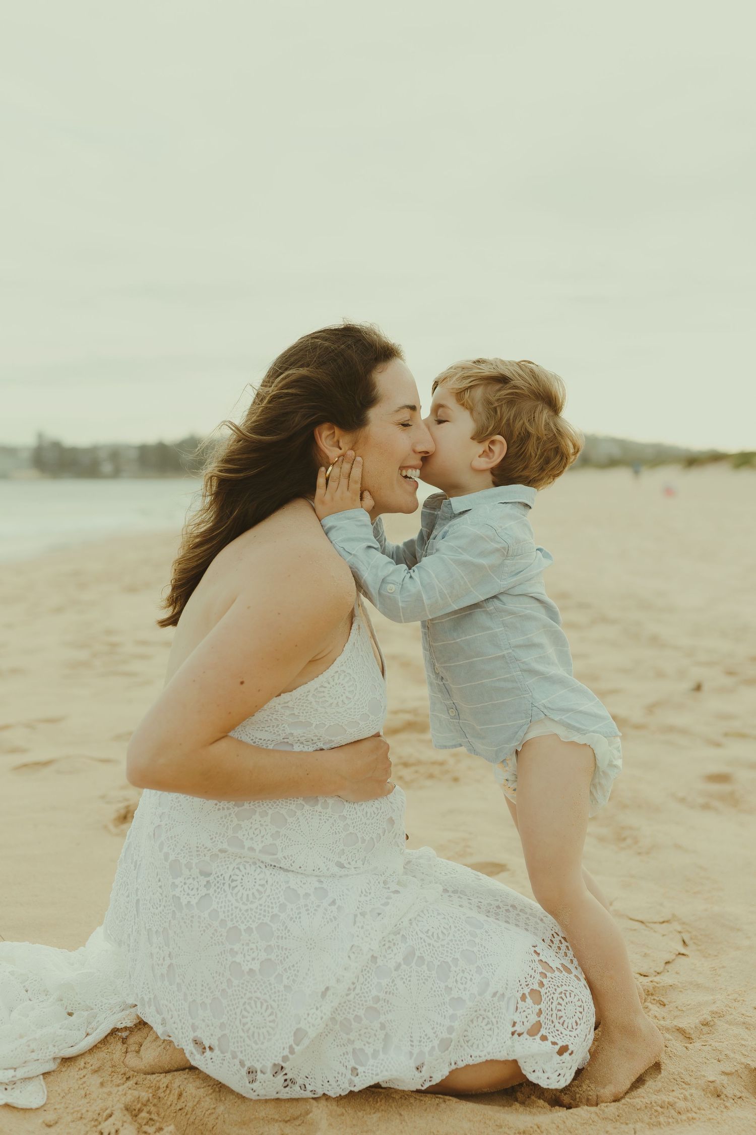 Sweet interactions between parent and child on a sandy beach at sunset.