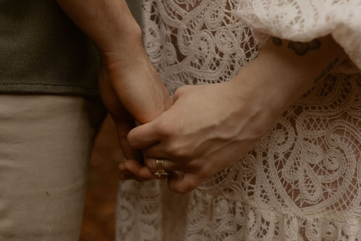 Detail of delicate lace wedding dress fabric against a natural outdoor background.