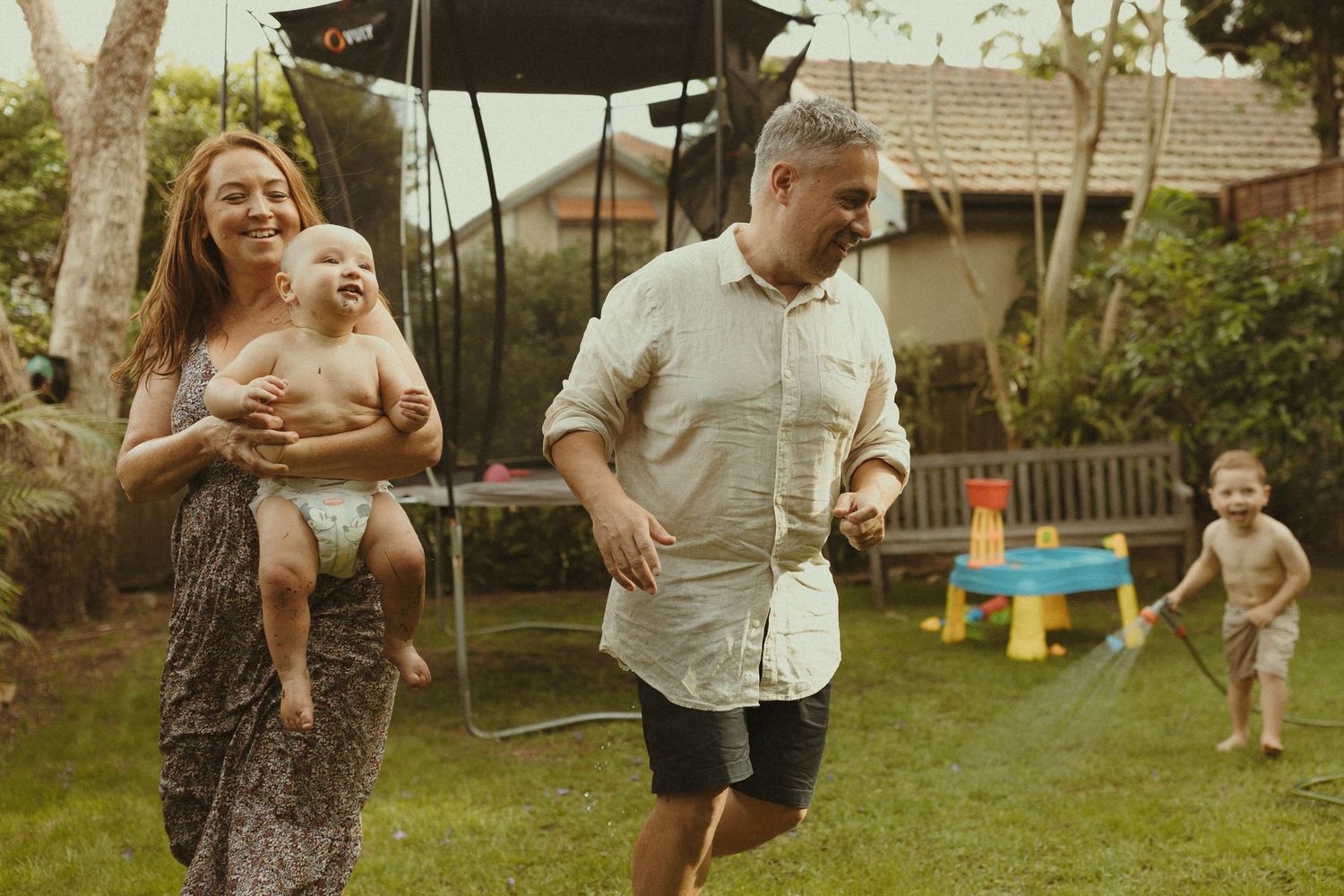 Candid family moments captured in a backyard setting with natural lighting and casual atmosphere.
