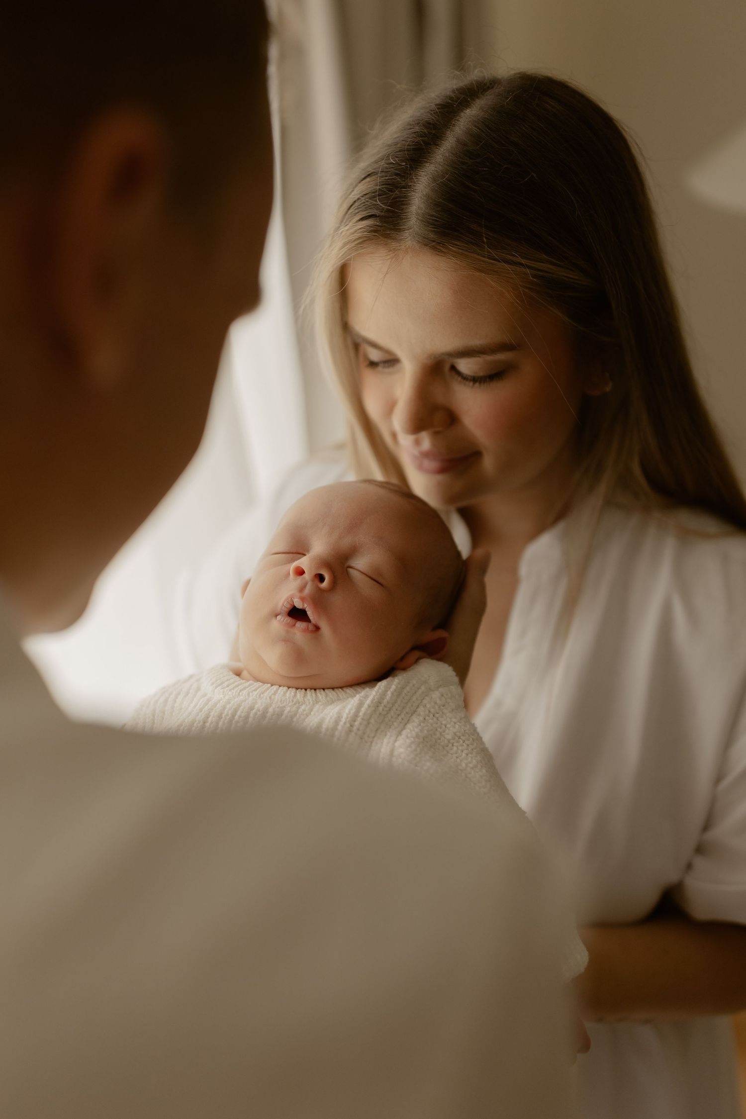 Intimate portrait series of parents sharing quiet moments with their sleeping newborn.
