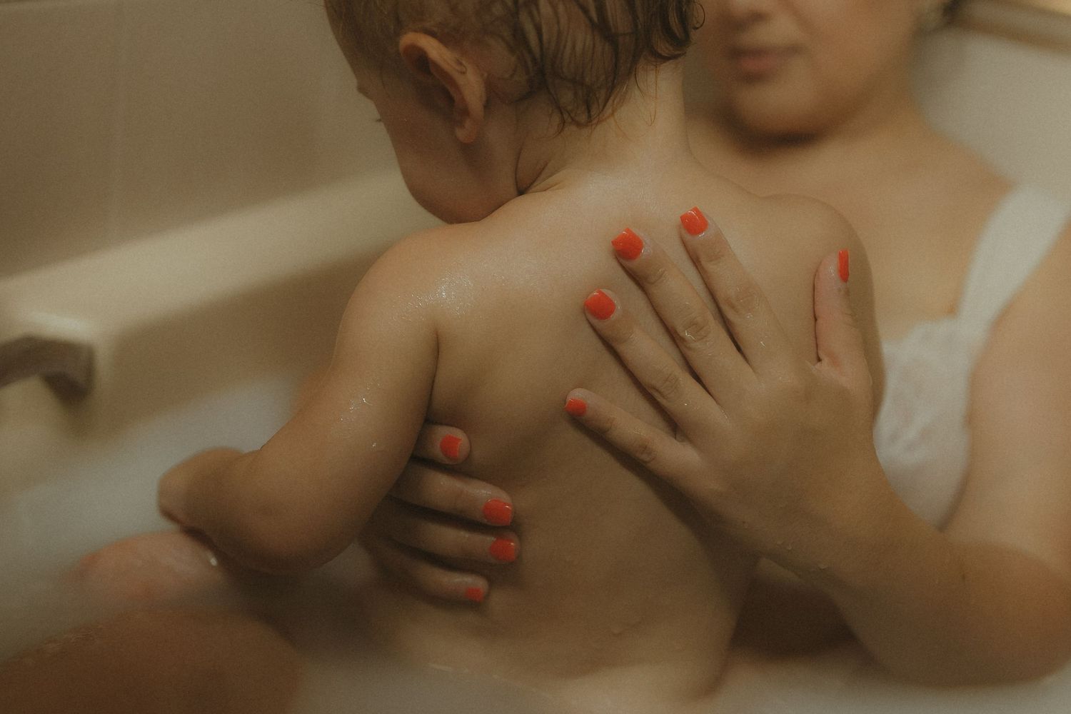 A series of intimate close-up photos showing hands gently touching skin in warm lighting.