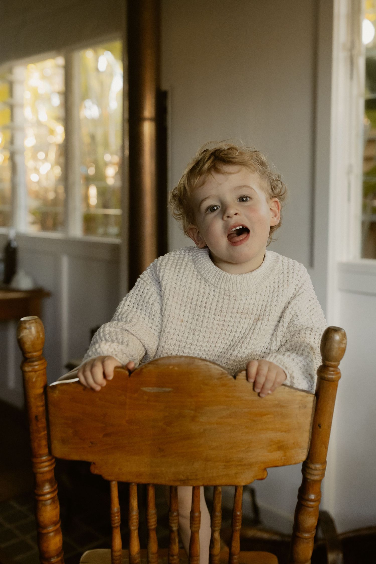 Cheerful scene by a wooden chair with warm natural lighting streaming through windows.