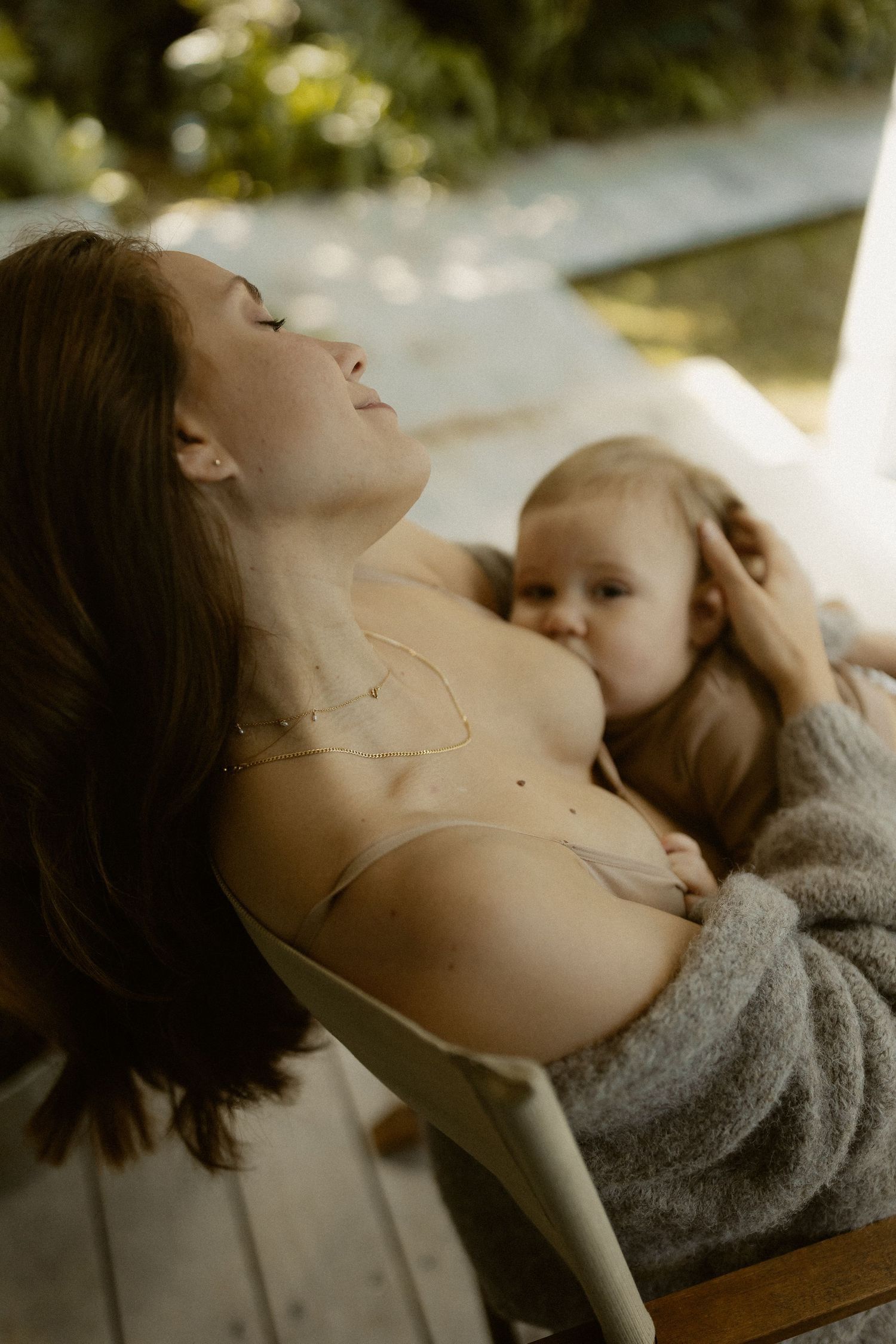 Gentle nurturing moment captured in soft natural lighting on wooden porch furniture.