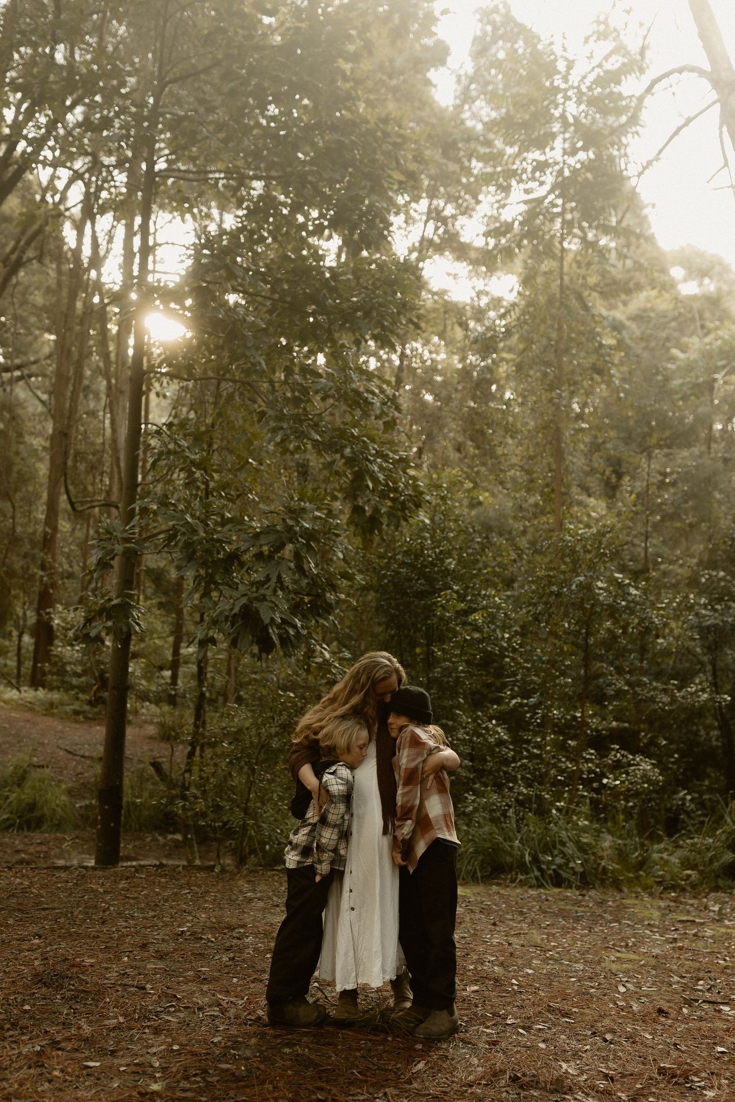 Intimate family moment captured in a misty forest setting.