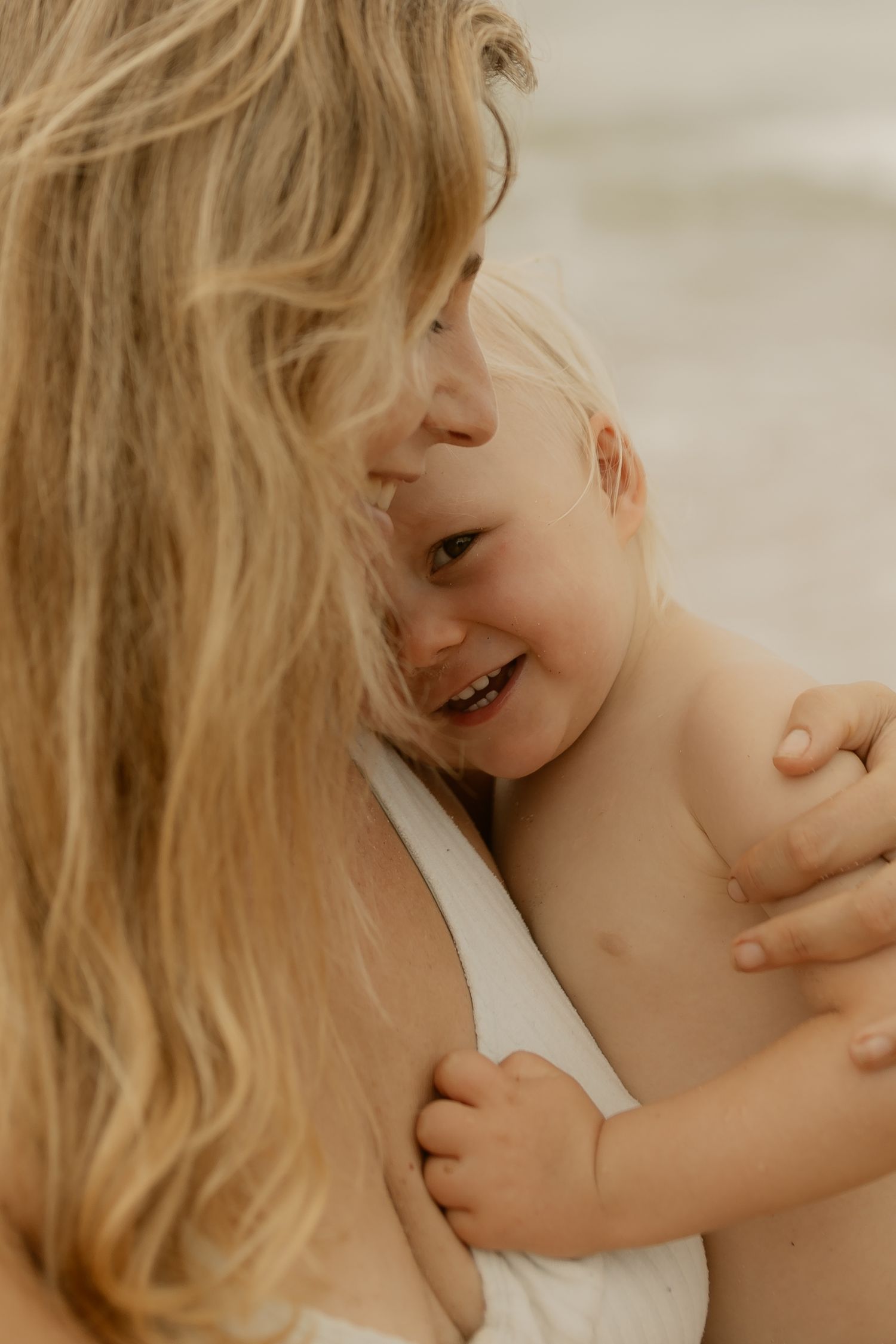 A tender moment captured showing a parent and child sharing an intimate embrace in warm, natural lighting.