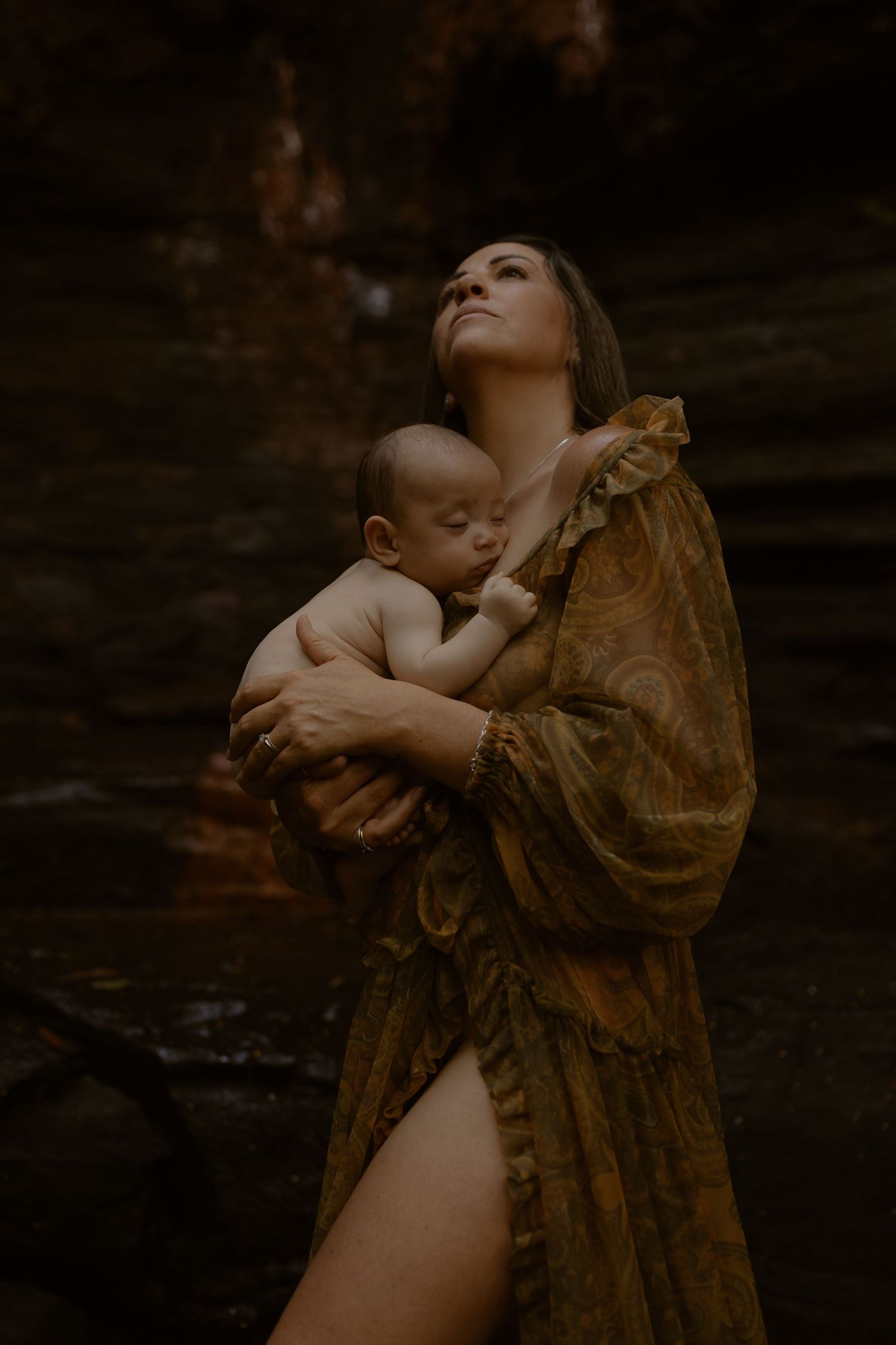 Intimate artistic portrait in dark moody lighting with brown fabric creating dramatic shadows.
