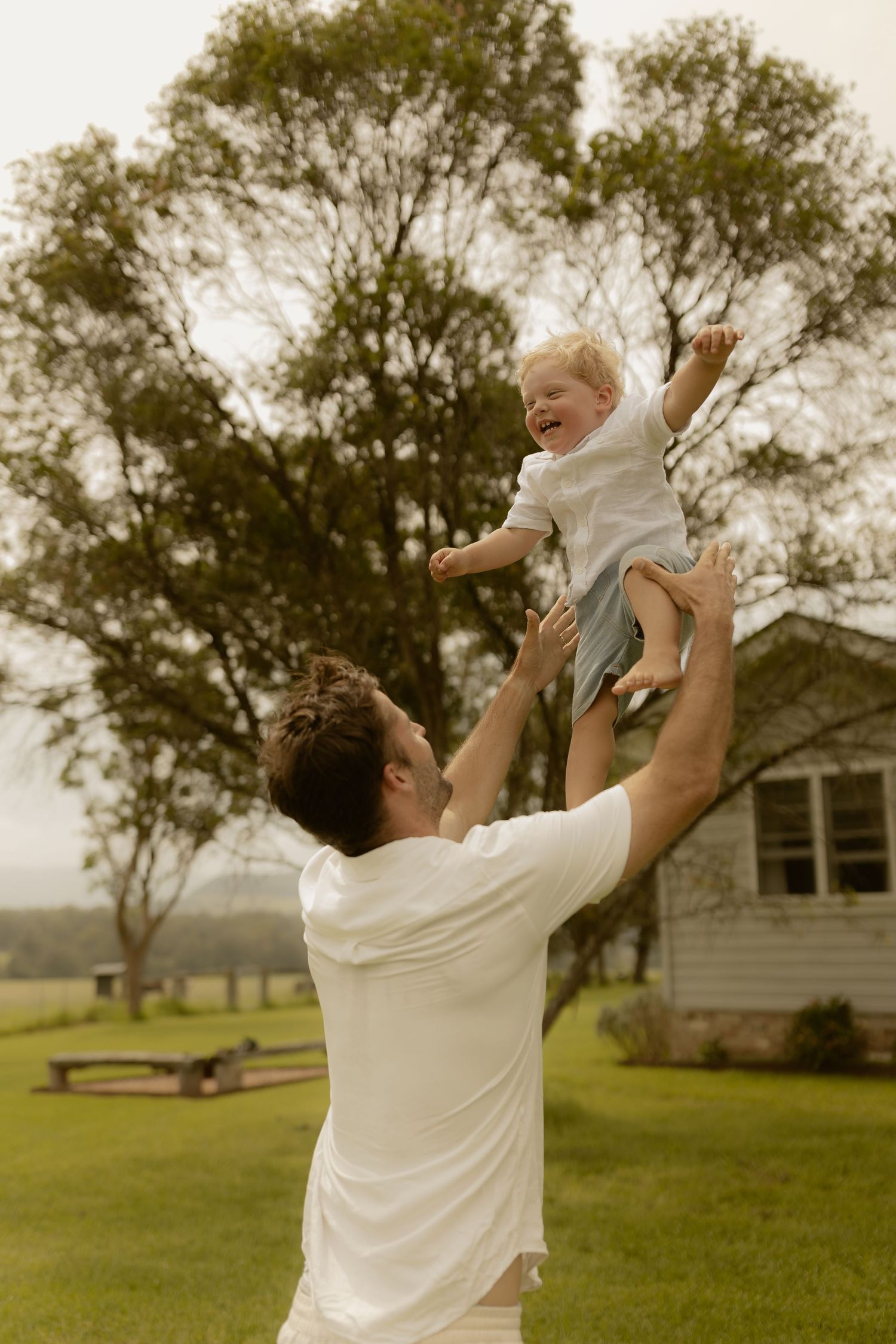 A joyful moment of play in a backyard with rolling hills in the distance.