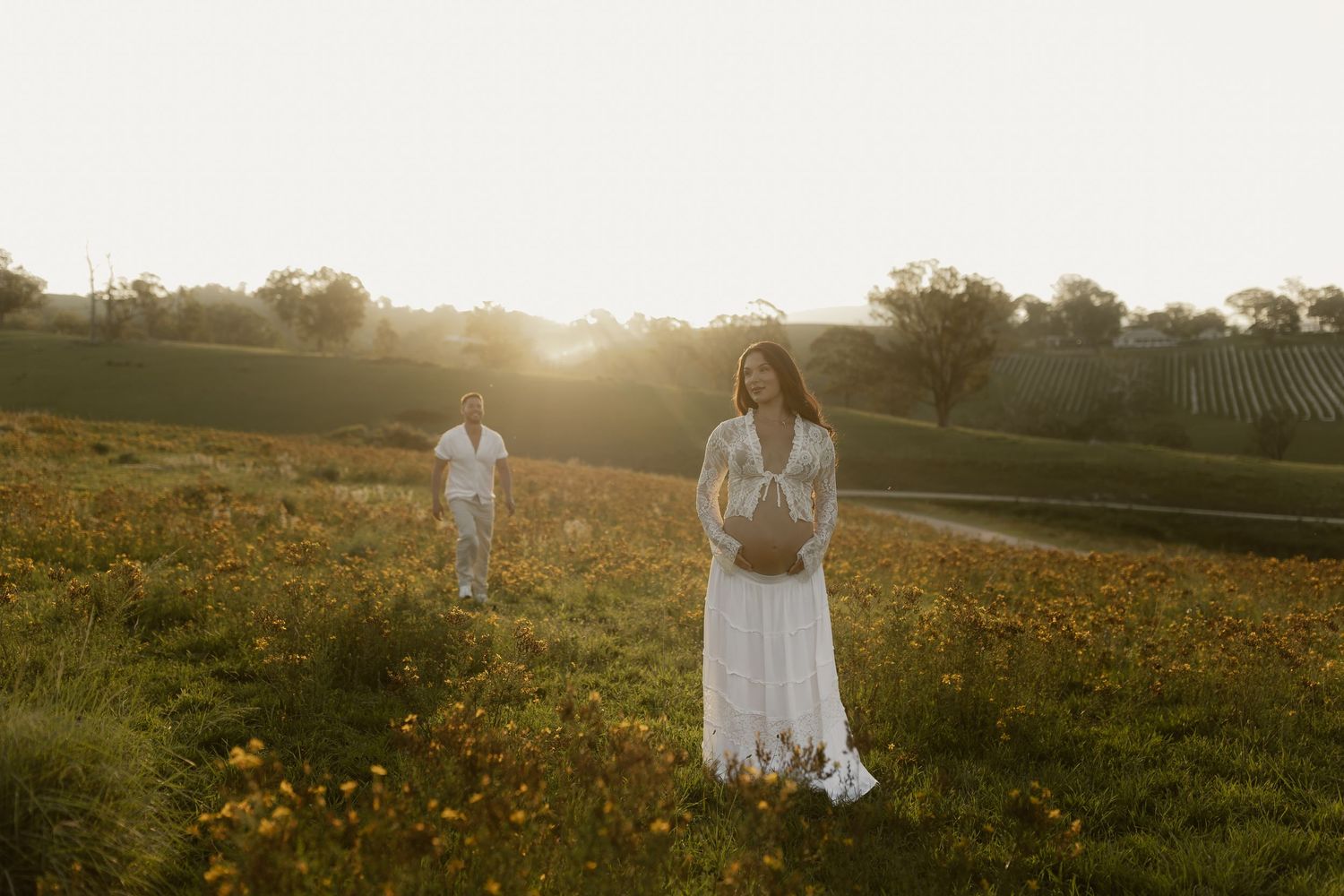 Ethereal figures dance through a field of wildflowers at sunset.